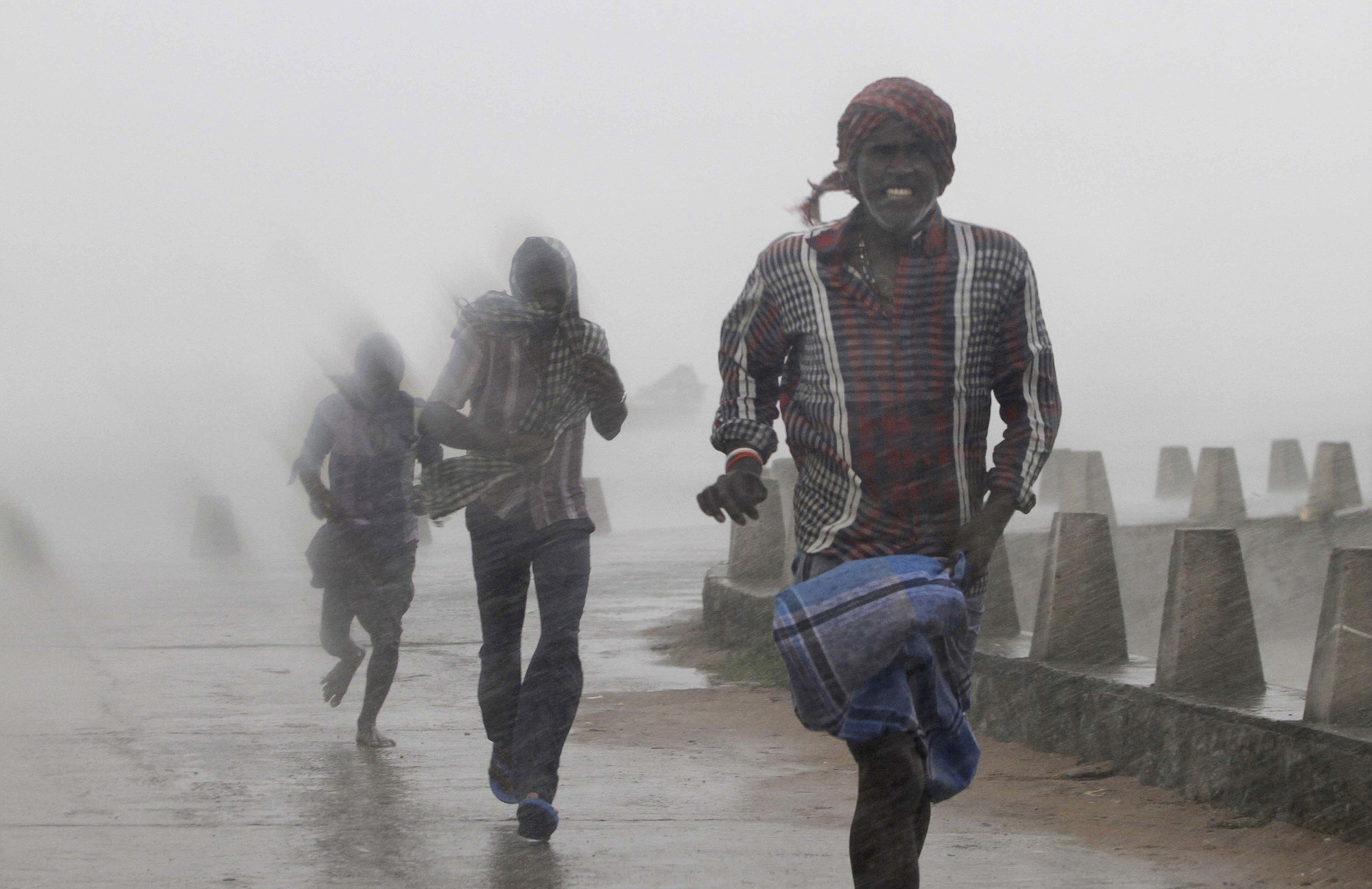 People run for shelter Sunday as heavy rain and wind gusts rip through the Bay of Bengal coast at Gopalpur, Orissa, about 178 miles north east of Visakhapatnam, India.