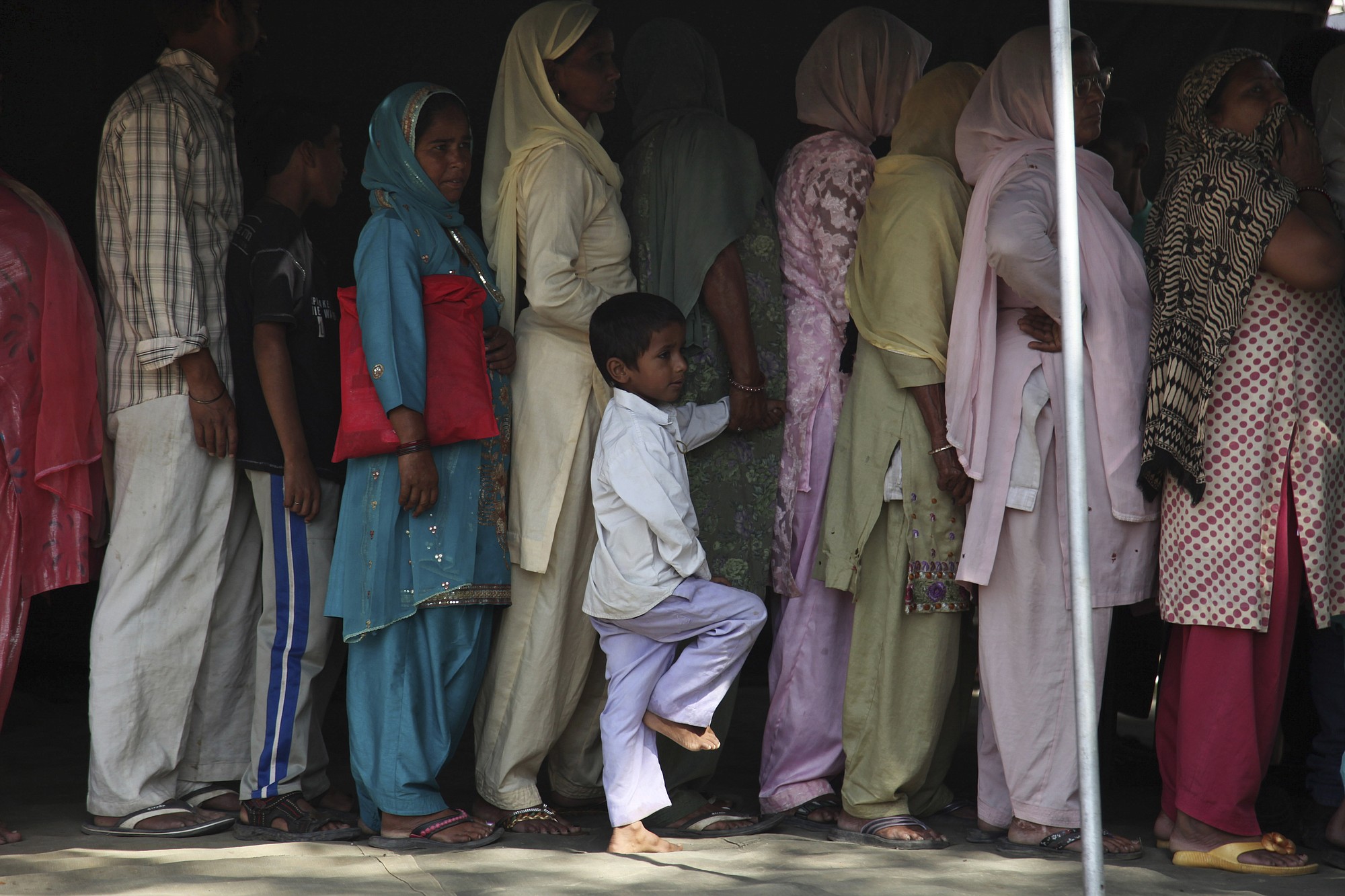 Indian villagers who fled from their homes near the Pakistan border line up for a medical check up at an army relief camp at Deoli village, in Arnia sector of Jammu and Kashmir state, India, on Thursday.