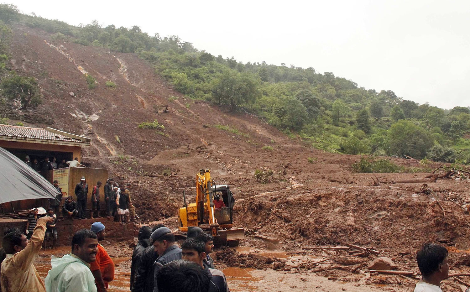 A rescuer clears debris with the help of an excavator at the site of a landslide in Malin village, in the western Indian state of Maharashtra on Wednesday.