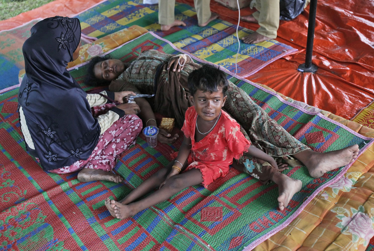 A Rohingya girl cries next to her sick mother Thursday at a temporary shelter in Bayeun, Indonesia.