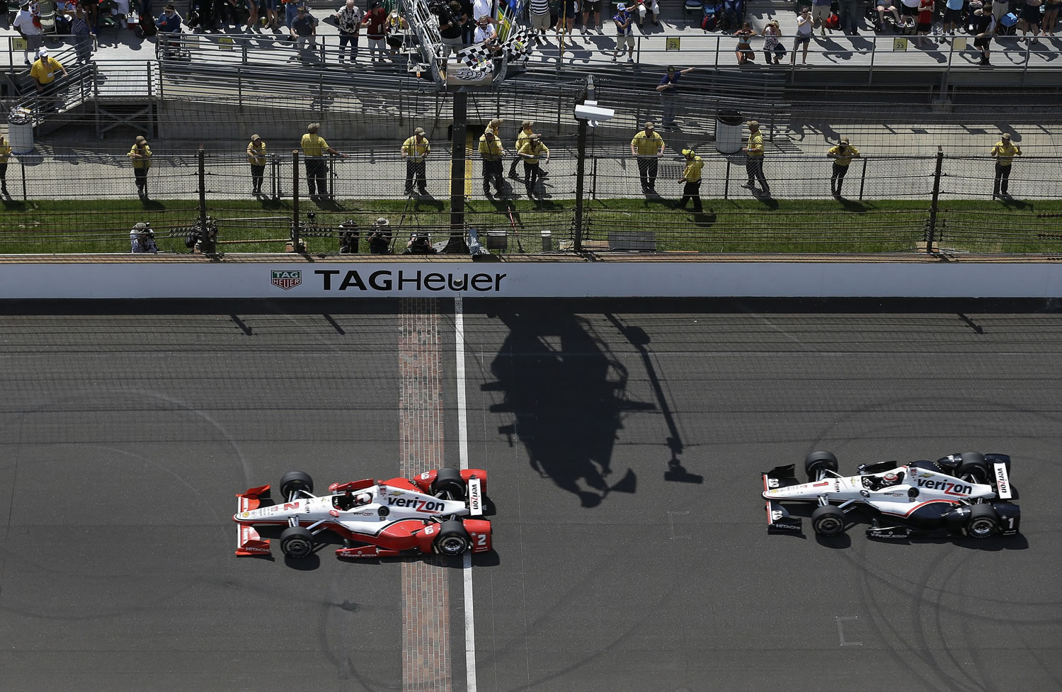Juan Pablo Montoya takes the checkered flags ahead of Will Power to win the 99th running of the Indianapolis 500 on Sunday, May 24, 2015.