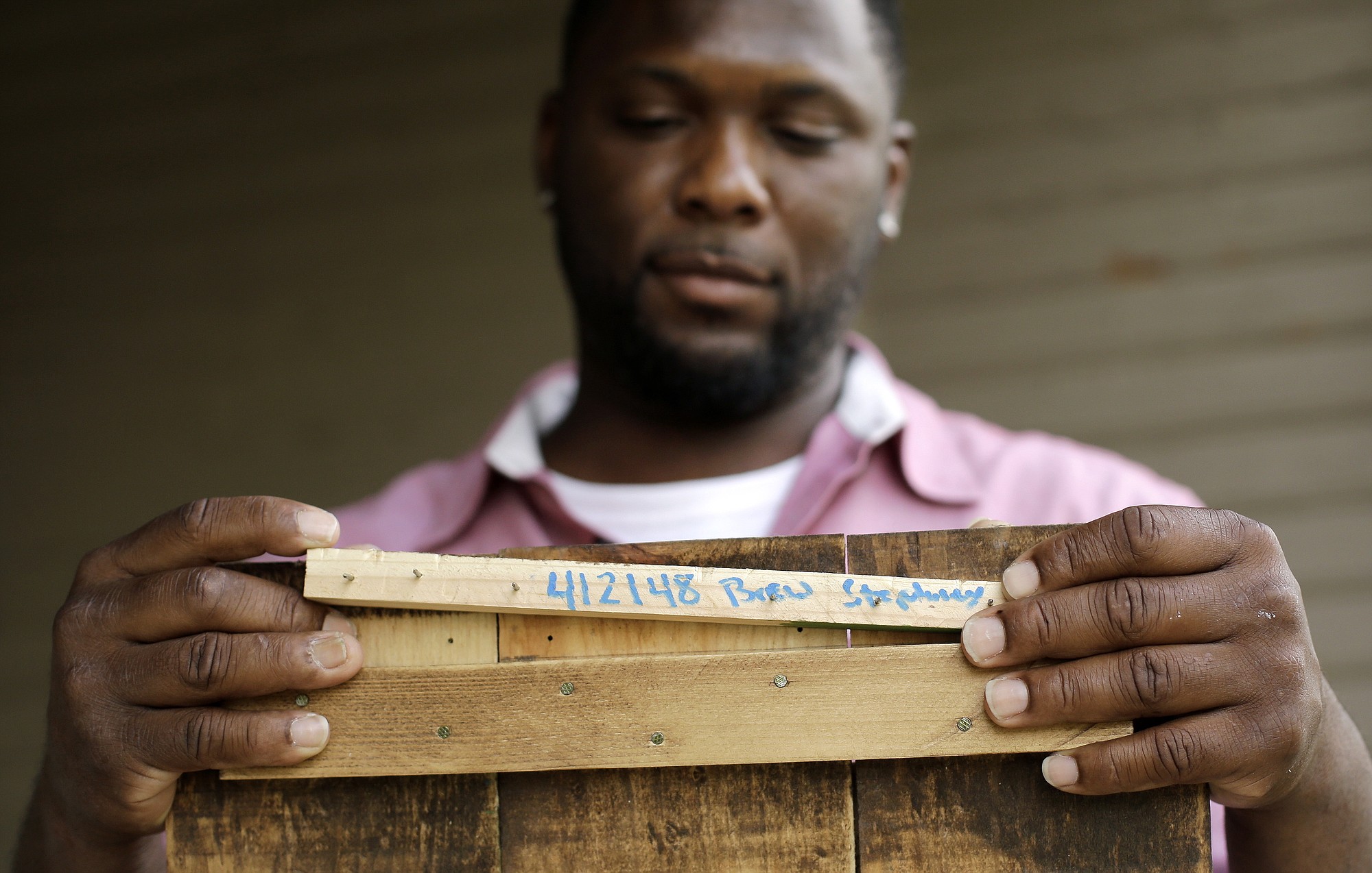 Larry Stephney holds a piece of wood with the number 412148 written on it that is from a product made while he was an inmate at a privately run prison in Nashville, Tenn.