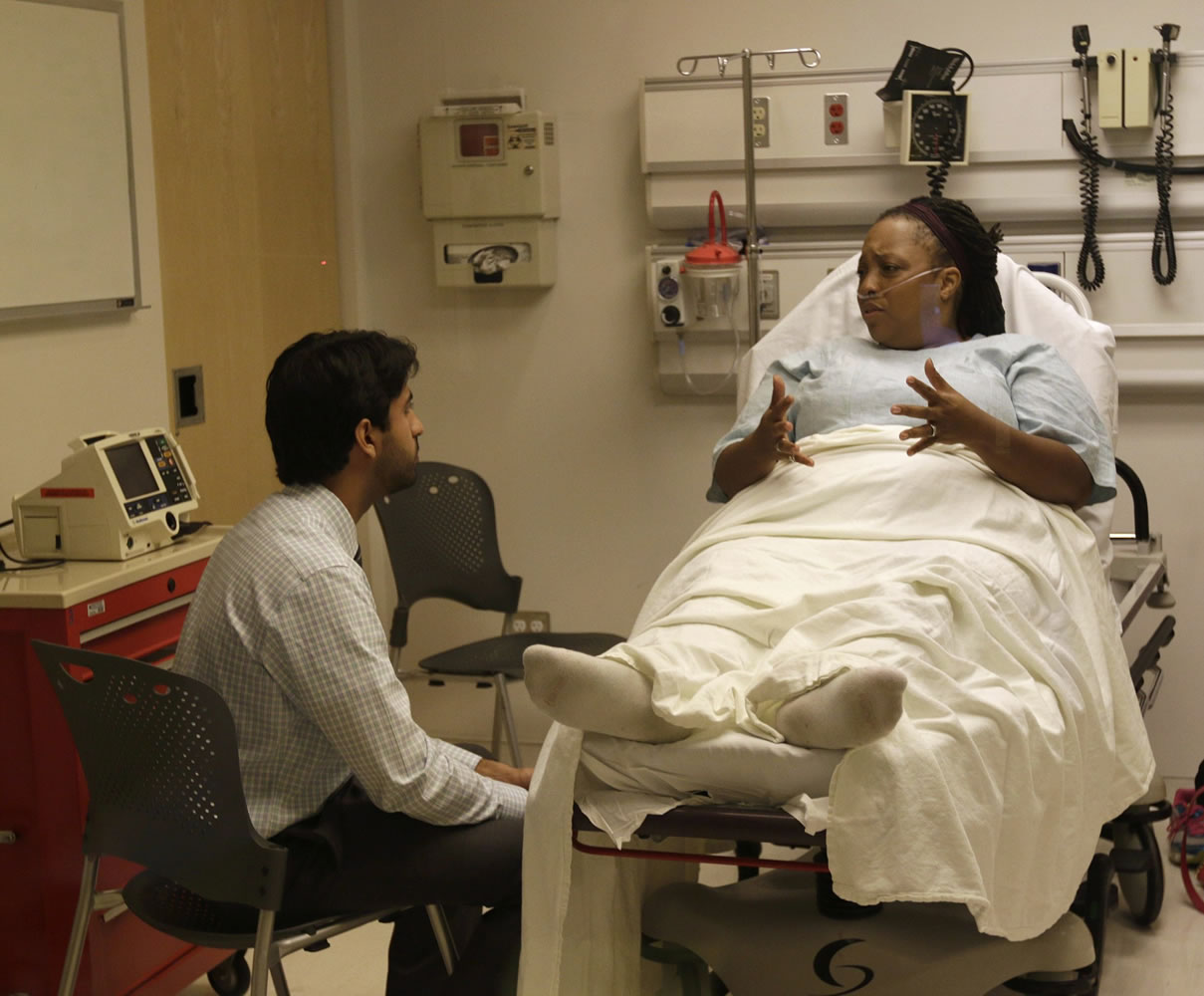 In this June 25, 2014 photo, Atif Sheikh, left, practices giving bad news to a patient played by an actor during an intern boot camp exercise taught by Northwestern Memorial Hospital and Northwestern University's Feinberg School of Medicine in Chicago.