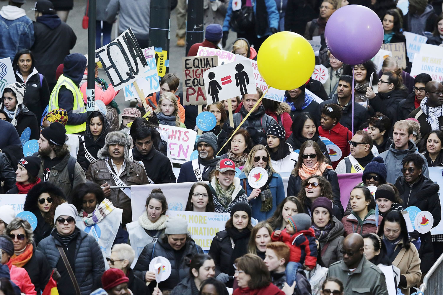 People walk in the International Women's Day march for gender equality and women's rights from the United Nations to Times Square, on Sunday in New York.
