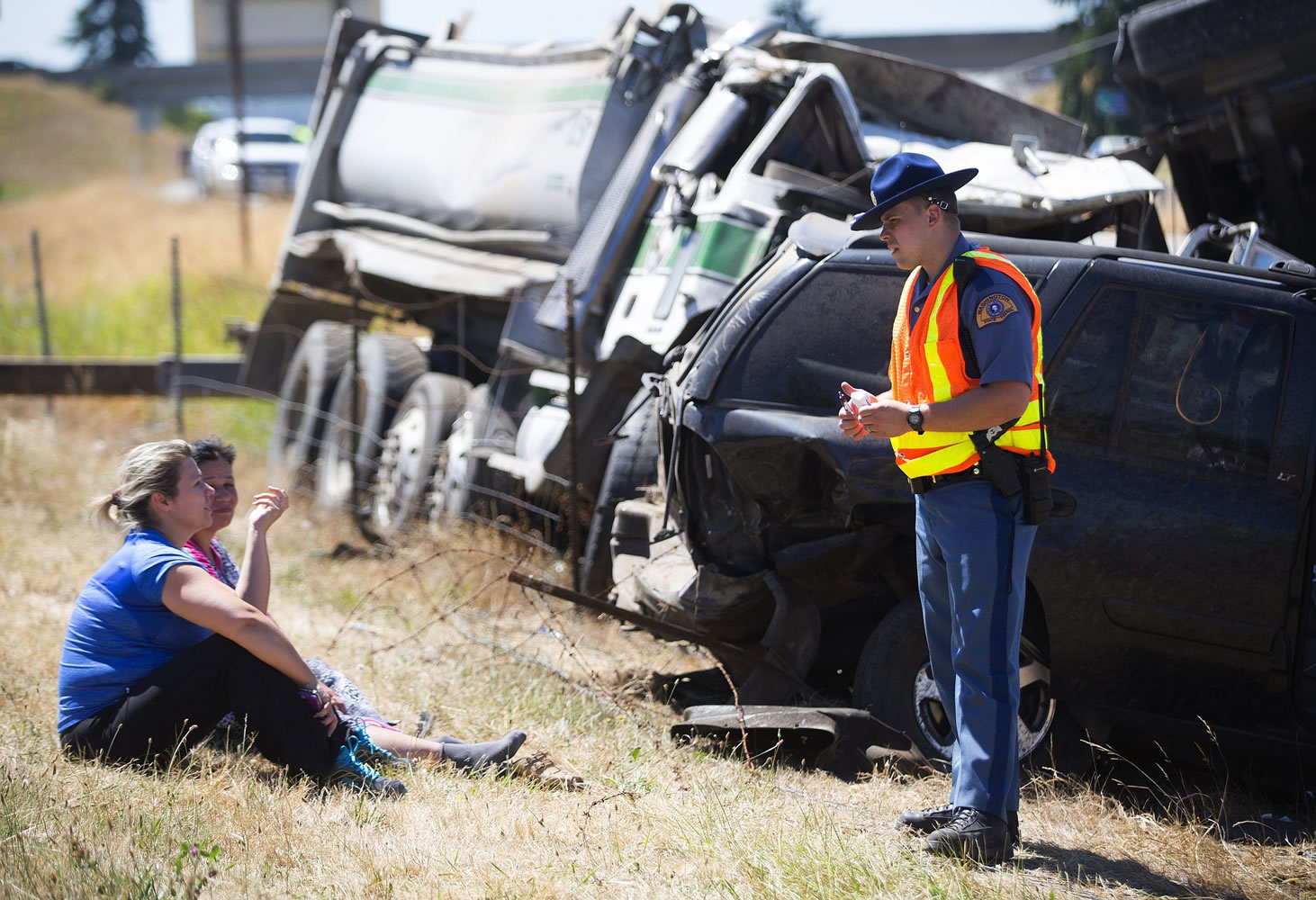 Washington State Patrol officer Mark Francis talks people who were in a large accident involving a truck carrying gravel Saturday on Interstate 5 north of Seattle.
