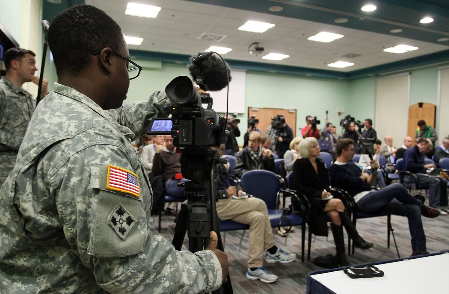 Journalist listen as Major General Darryl A. Williams, the commanding general of U.S. Army Africa, conducts a press conference via video teleconferencing at the Camp Ederle U.S.