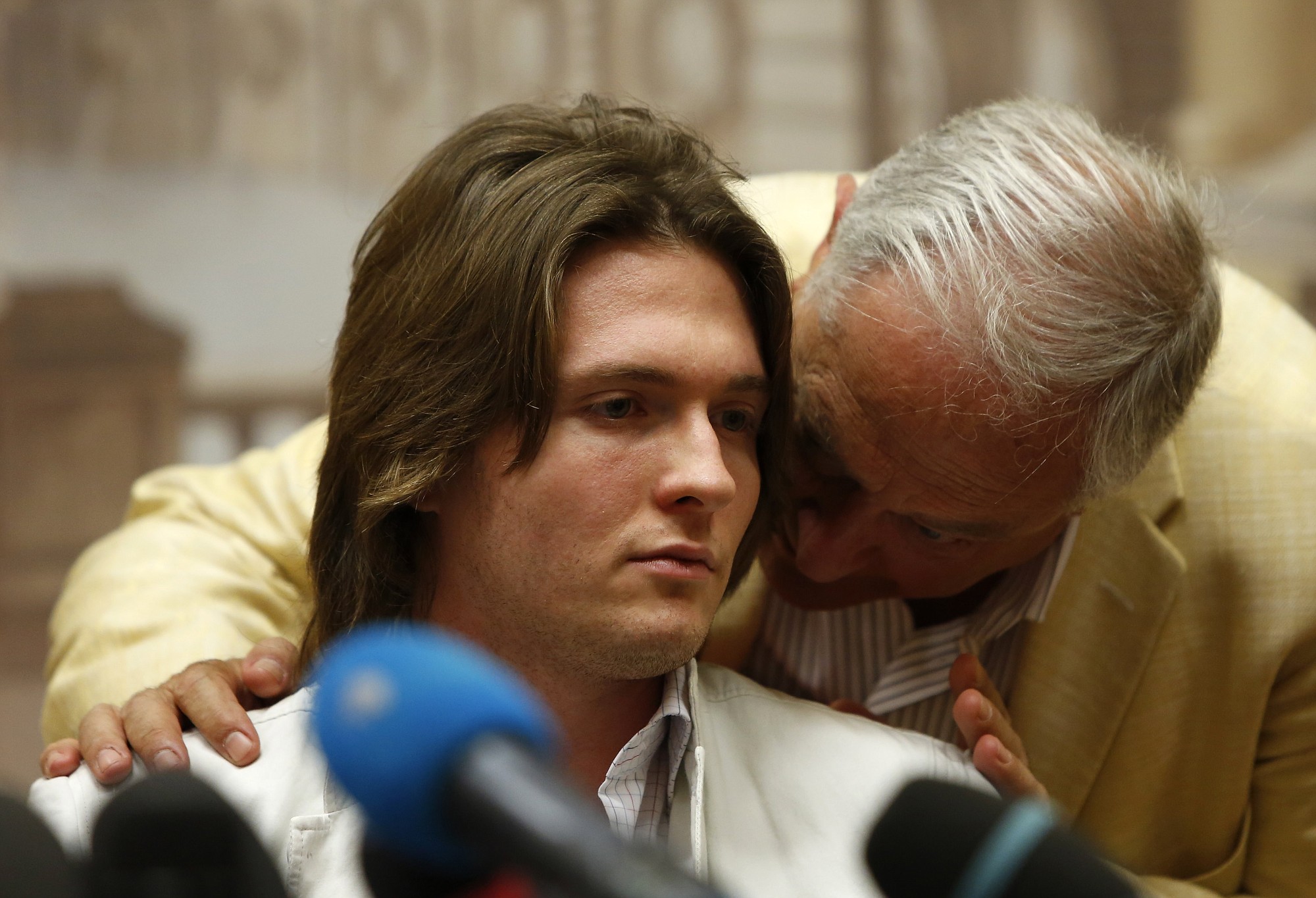Raffaele Sollecito listens to his father, Francesco Sollecito, right, during a press conference in Rome on Tuesday.