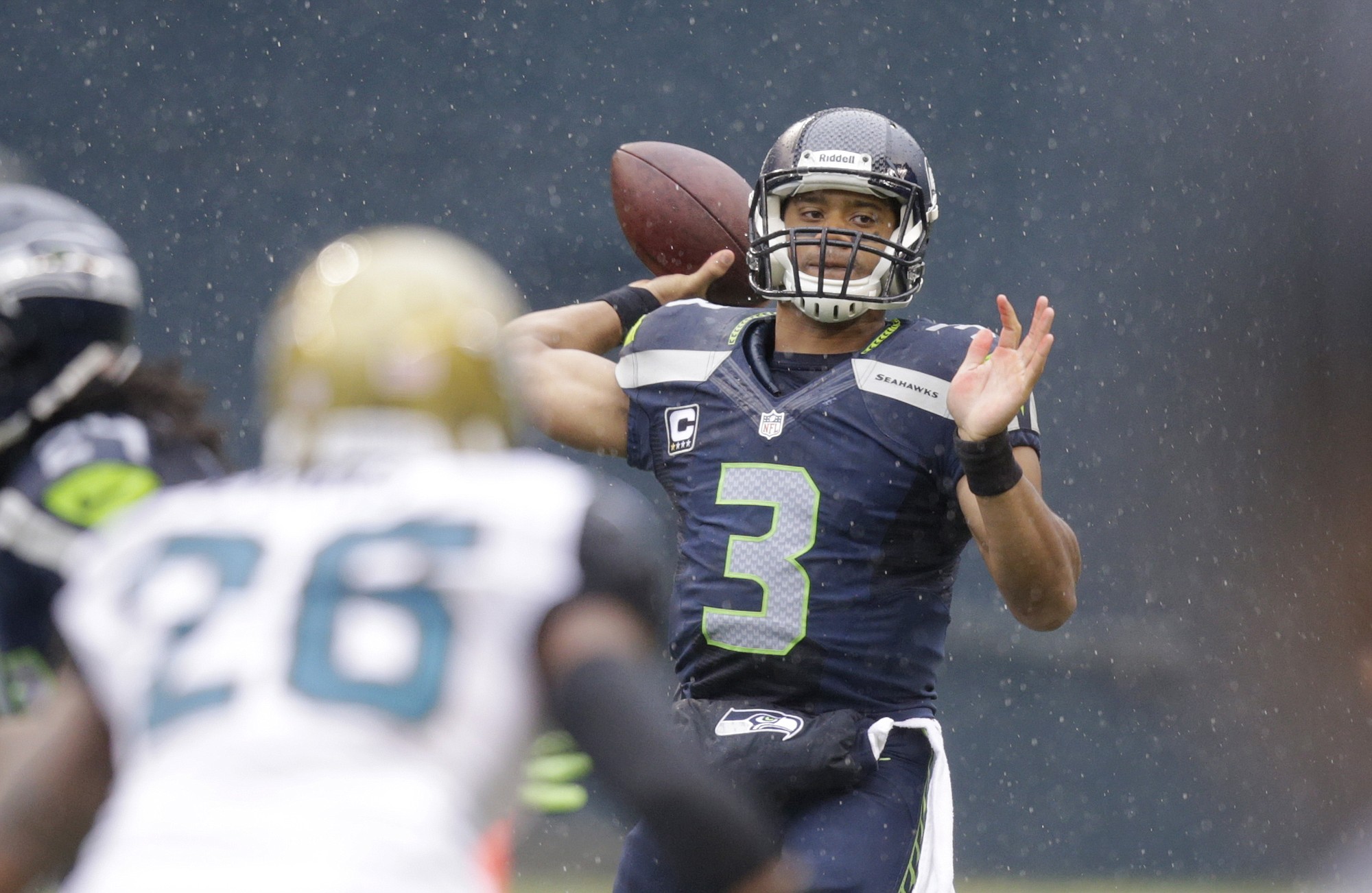 Seattle Seahawks quarterback Russell Wilson throws against the Jacksonville Jaguars in the first half of an NFL football game in the rain on Sunday, Sept. 22, 2013, in Seattle.