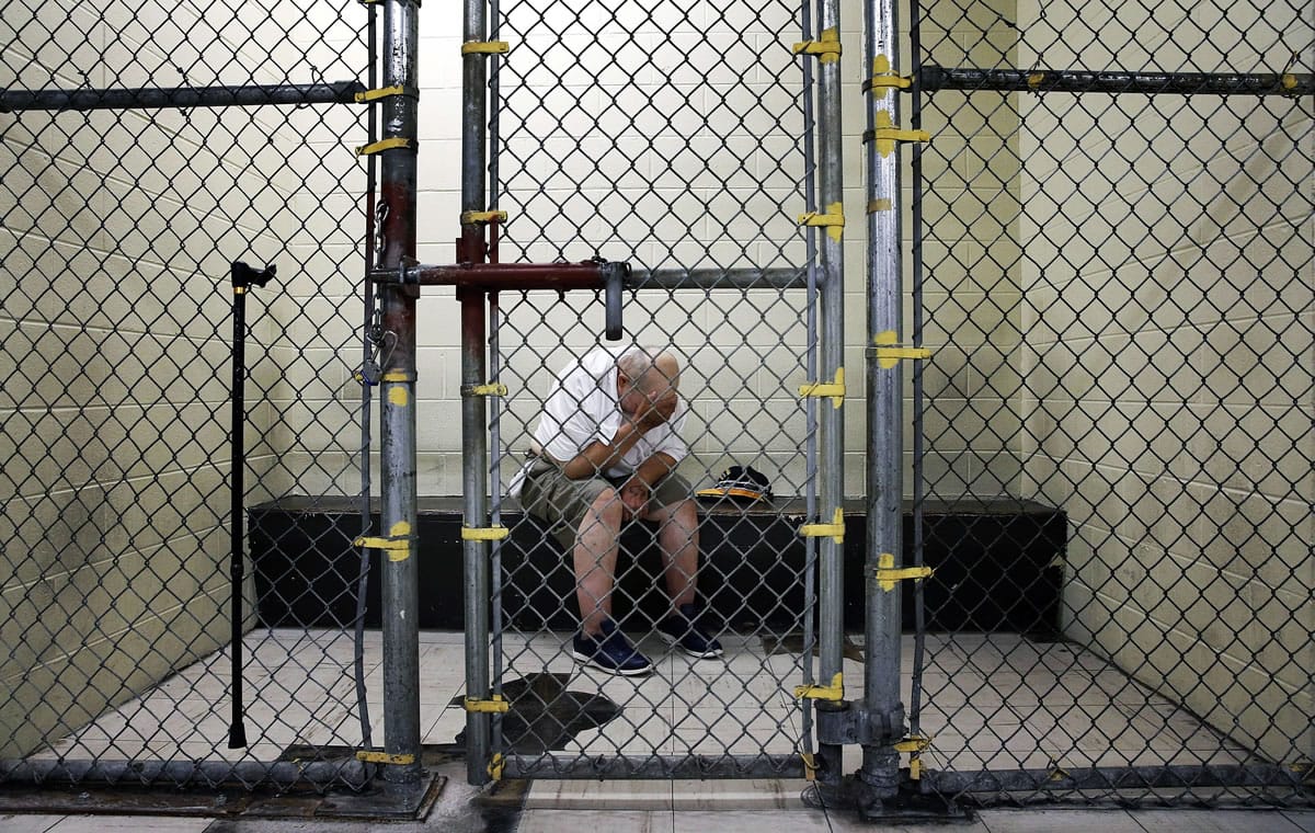 A veteran with post-traumatic stress disorder sits in a segregated holding pen at the Cook County Jail after he was arrested on a narcotics charge in Chicago.