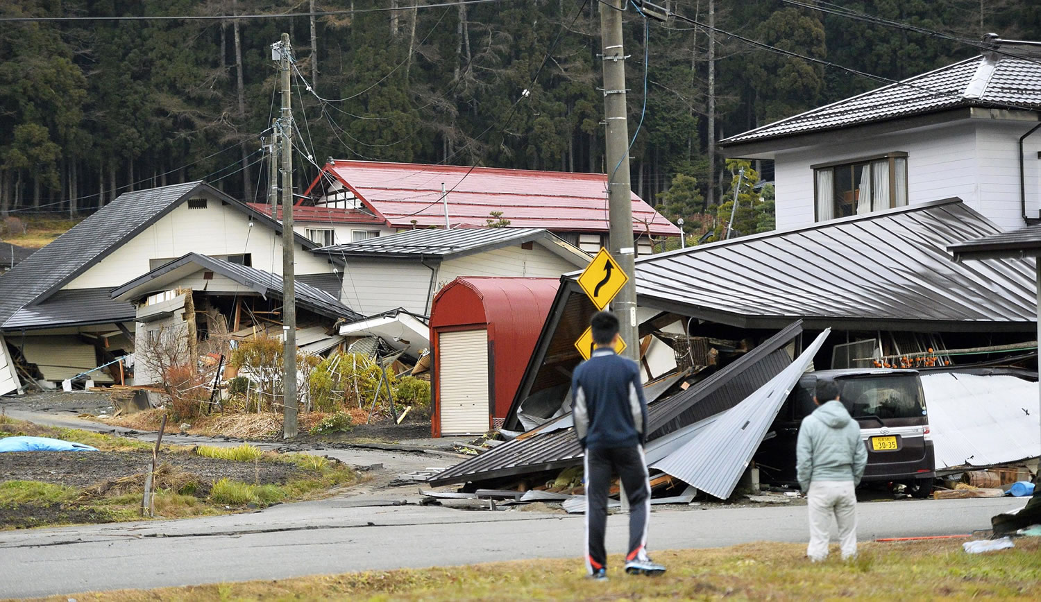 Residents look at collapsed houses early today after a strong earthquake Saturday night in Hakuba, Nagano prefecture, Japan.