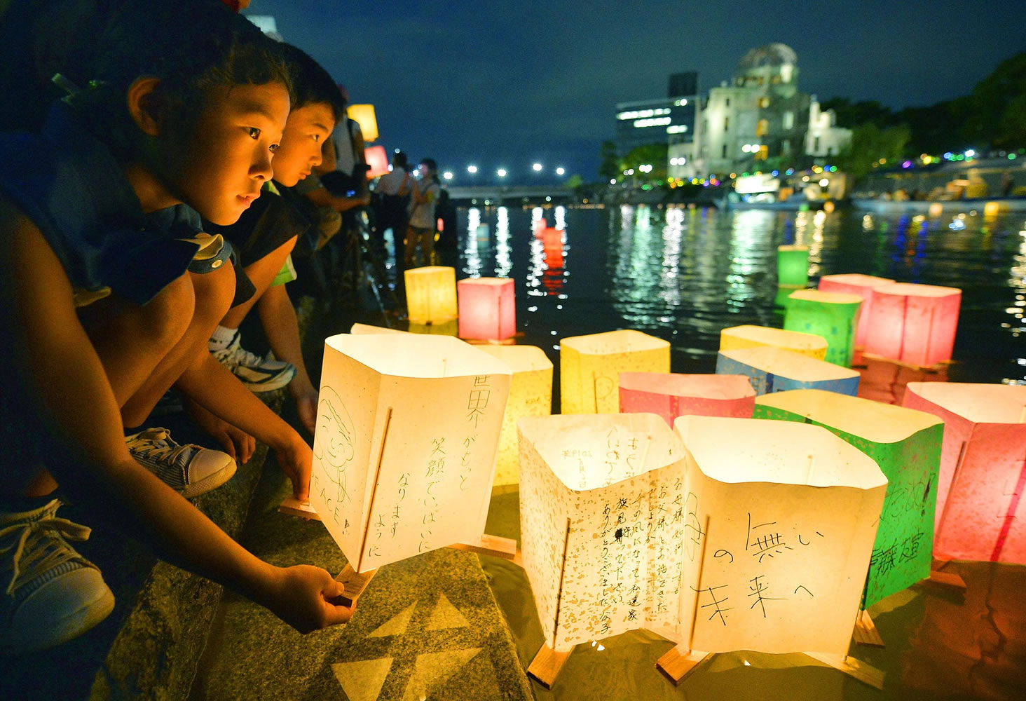Kyodo News/Associated Press
A girl prepares to release paper lanterns with messages of peace on them Wednesday in the Motoyasu River near the Atomic Bomb Dome in Hiroshima, Japan.