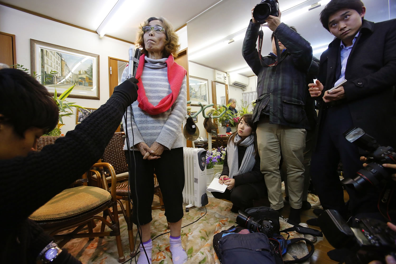 Junko Ishido, center left, the mother of Japanese journalist Kenji Goto who is being held hostage by the Islamic State group, listens to reporter's question during a press conference at her home in Koganei on the outskirts of Tokyo late Thursday.