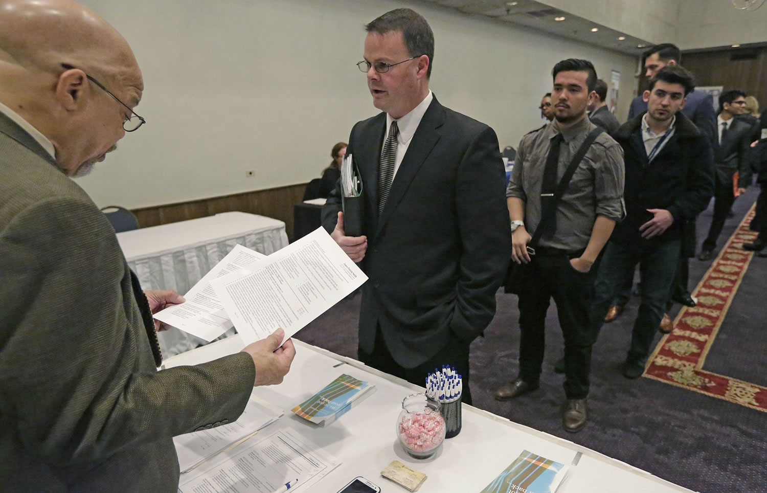 Ralph Logan, general manager of Microtrain, left, speaks with James Smith who is seeking employment April 22 during a National Career Fairs job fair in Chicago. The U.S.