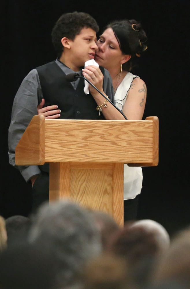 Andrea Irwin comforts her son, Jordan Robinson, 15, as he speaks during a funeral service for his 19-year-old brother, Tony Robinson, at Madison East High School on Saturday in Madison, Wis.