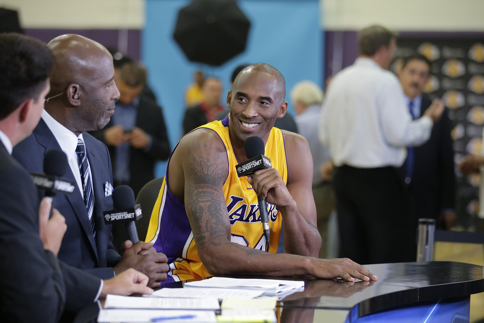 Los Angeles Lakers' Kobe Bryant, center, talks to former NBA star James Worthy during an interview on the team's media day Monday, Sept. 29, 2014, in El Segundo, Calif. (AP Photo/Jae C.