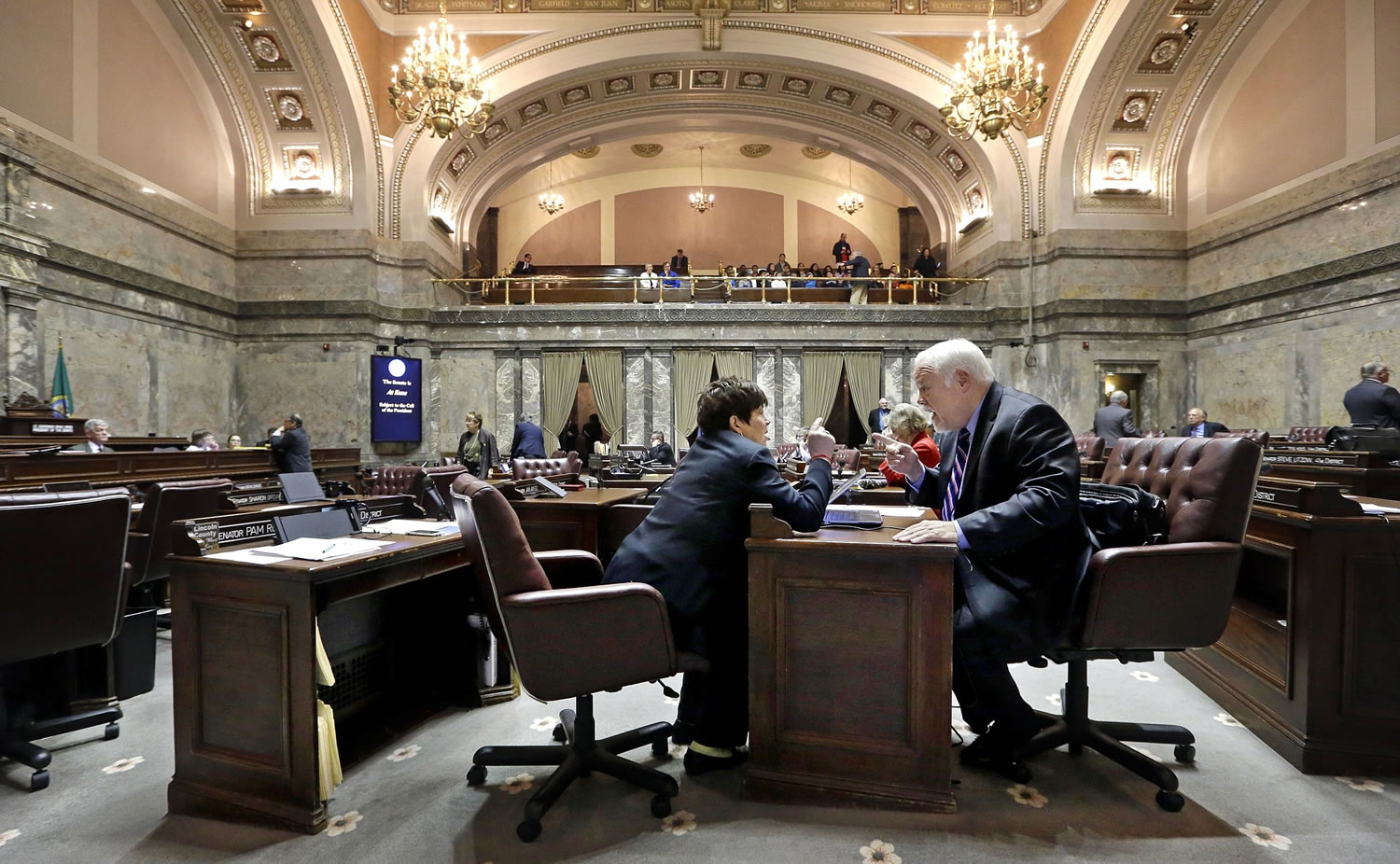 Sen. Pam Roach, R-Auburn, left, and Sen. Don Benton, R-Vancouver,  sit on the Senate floor and talk during a break on the first day of a 30-day special session of the Legislature Wednesday, April 29, 2015, in Olympia, Wash.