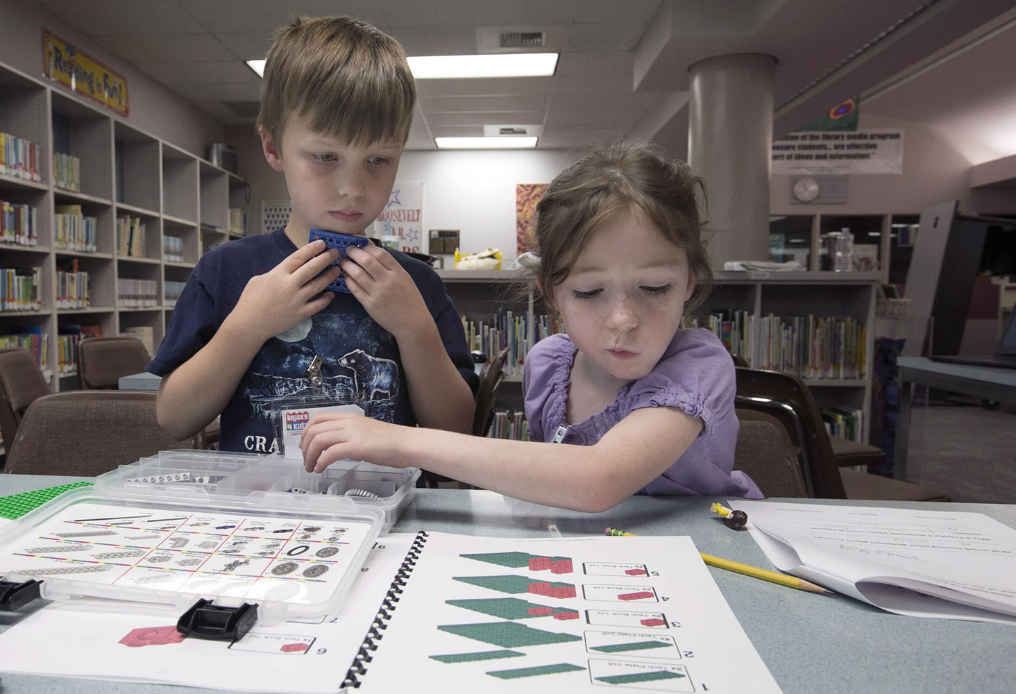 Students Joshua Whitney, 6, and Alison Dorn, 7, figure out how to assemble a seesaw from Legos on July 22 at Roosevelt Elementary in Yakima.