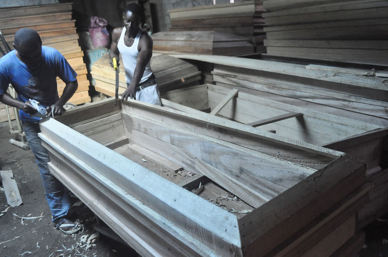 A carpenter makes caskets for sale Wednesday in Monrovia, Liberia.