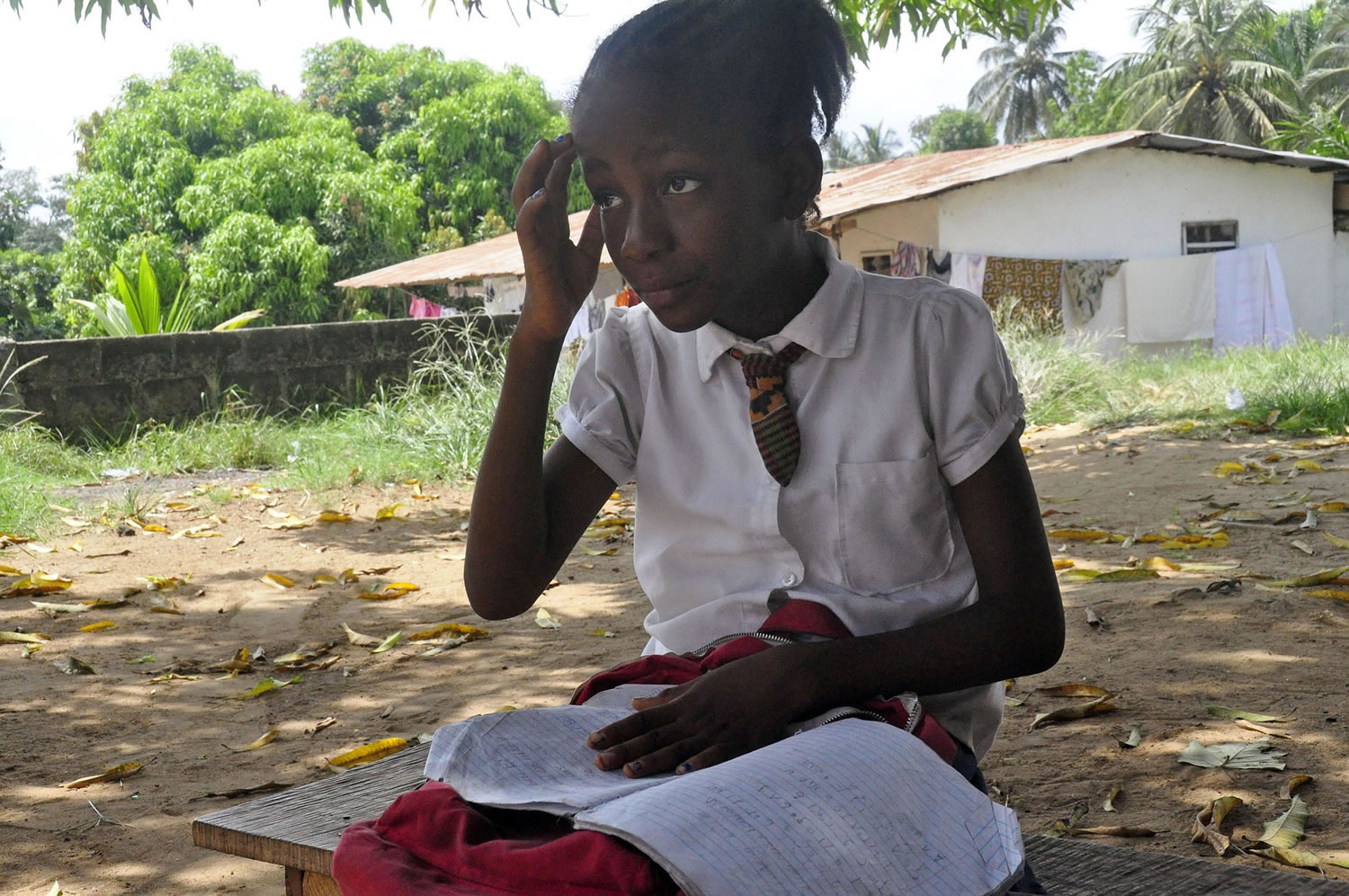Mercy Kennedy, 9, looks up as she does her homework after school at her home in Monrovia, Liberia, on May 8.