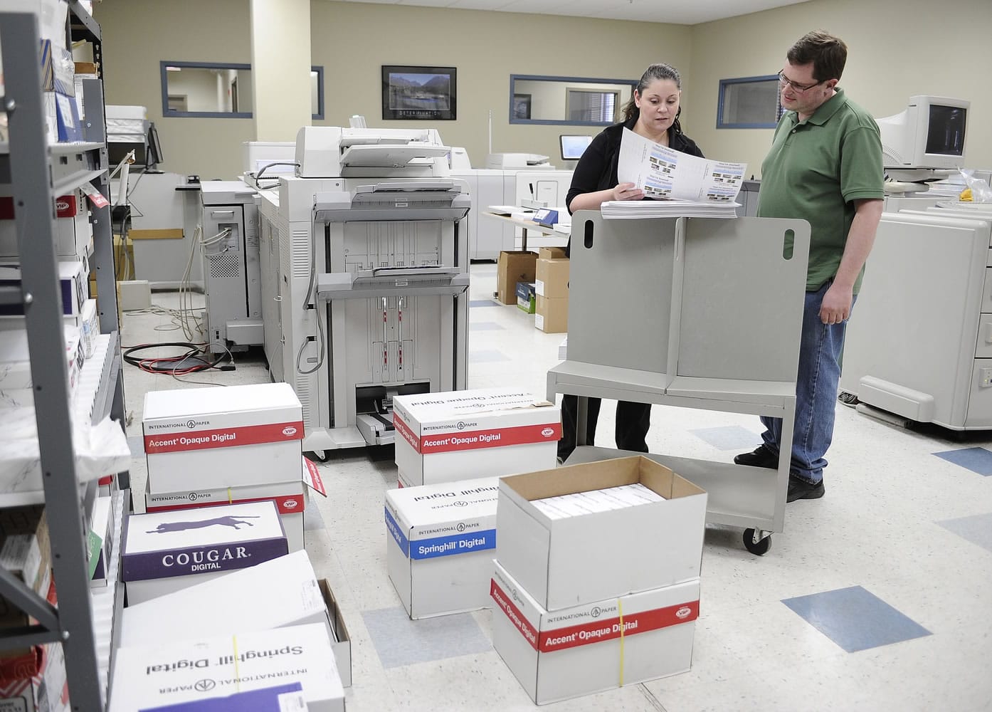 Bill Lewis, right, looks over a copy with colleague Rosie Rivera at CMS Mailing, in Monroe, Conn.