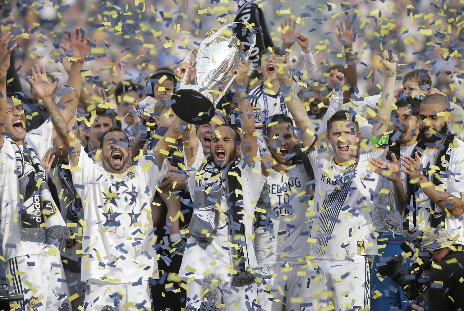 Los Angeles Galaxy's Landon Donovan, center, hoists the trophy as he and teammates celebrate after winning the MLS Cup championship against the New England Revolution on Sunday, Dec. 7, 2014, in Carson, Calif. (AP Photo/Jae C.