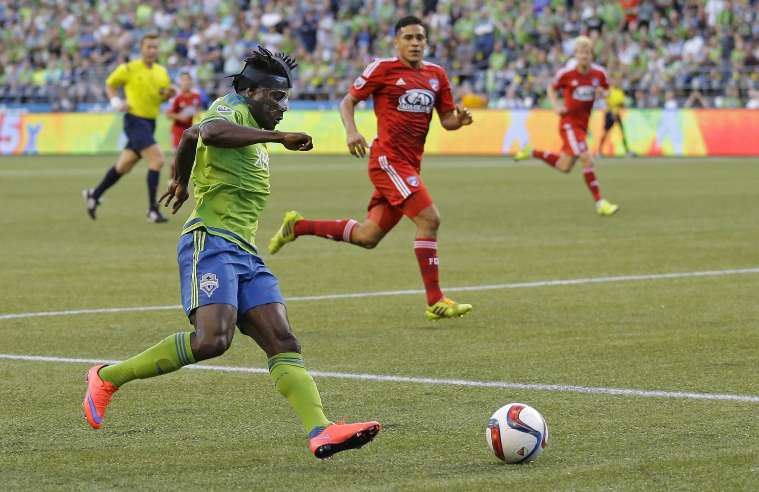 Seattle Sounders' Obafemi Martins, left, wearing a protective mask, goes in for a shot against FC Dallas during the second half Saturday, June 13, 2015, in Seattle. The Sounders won 3-0. (AP Photo/Ted S.