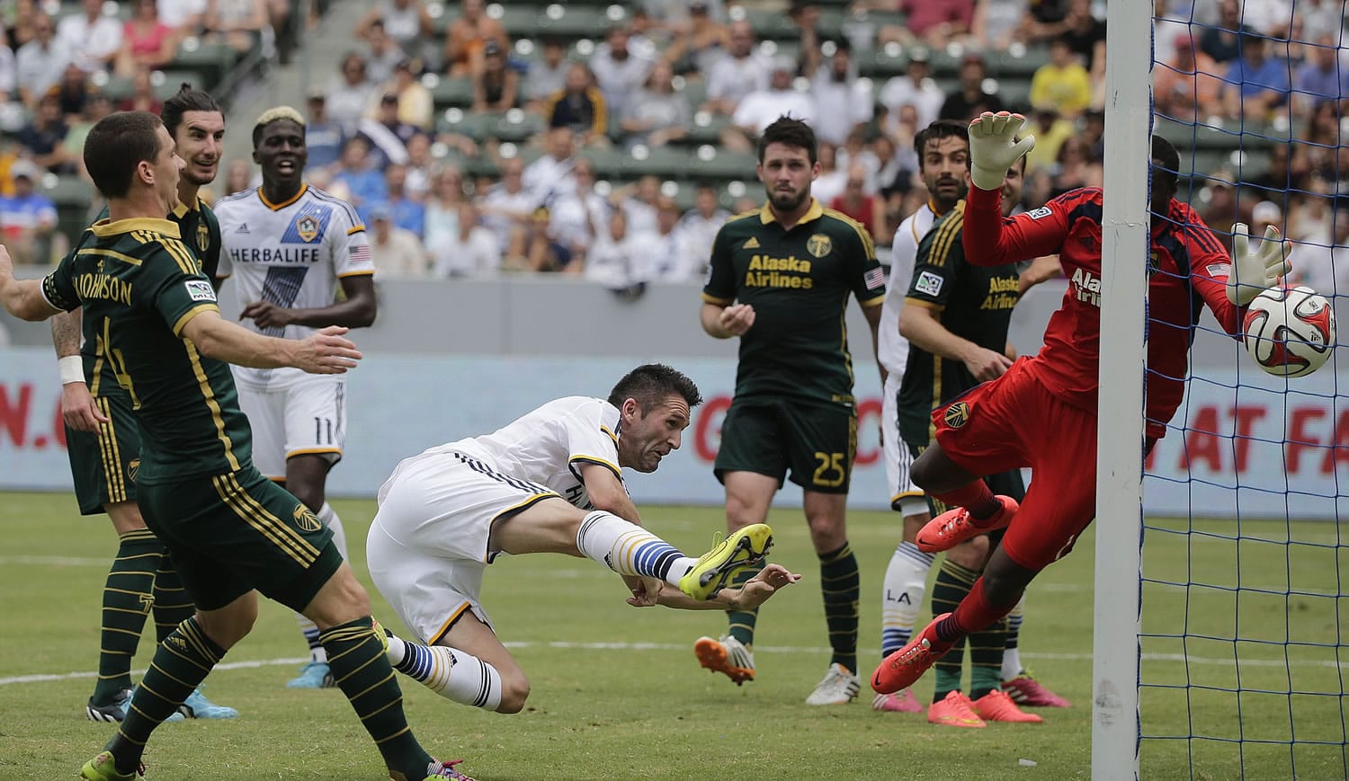 Los Angeles Galaxy's Robbie Keane, center, scores against Portland Timbers goalkeeper Donovan Ricketts during the second half Saturday, Aug. 2, 2014, in Carson, Calif. The Galaxy won 3-1. (AP Photo/Jae C.