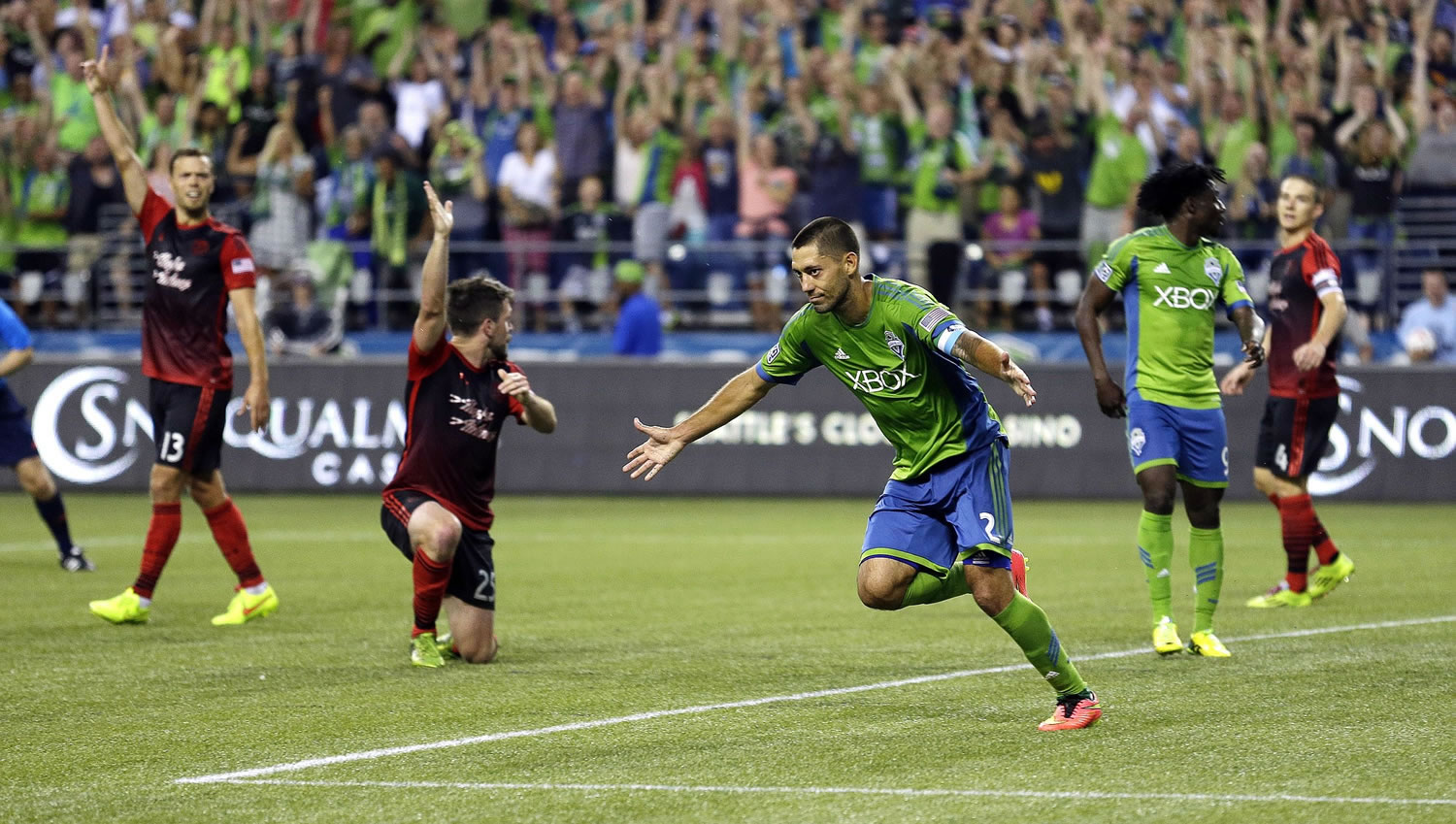 Seattle Sounders' Clint Dempsey, center, celebrates after scoring a goal against the Portland Timbers, in the second half of an MLS soccer match, Sunday, July 13, 2014, in Seattle. (AP Photo/Ted S.