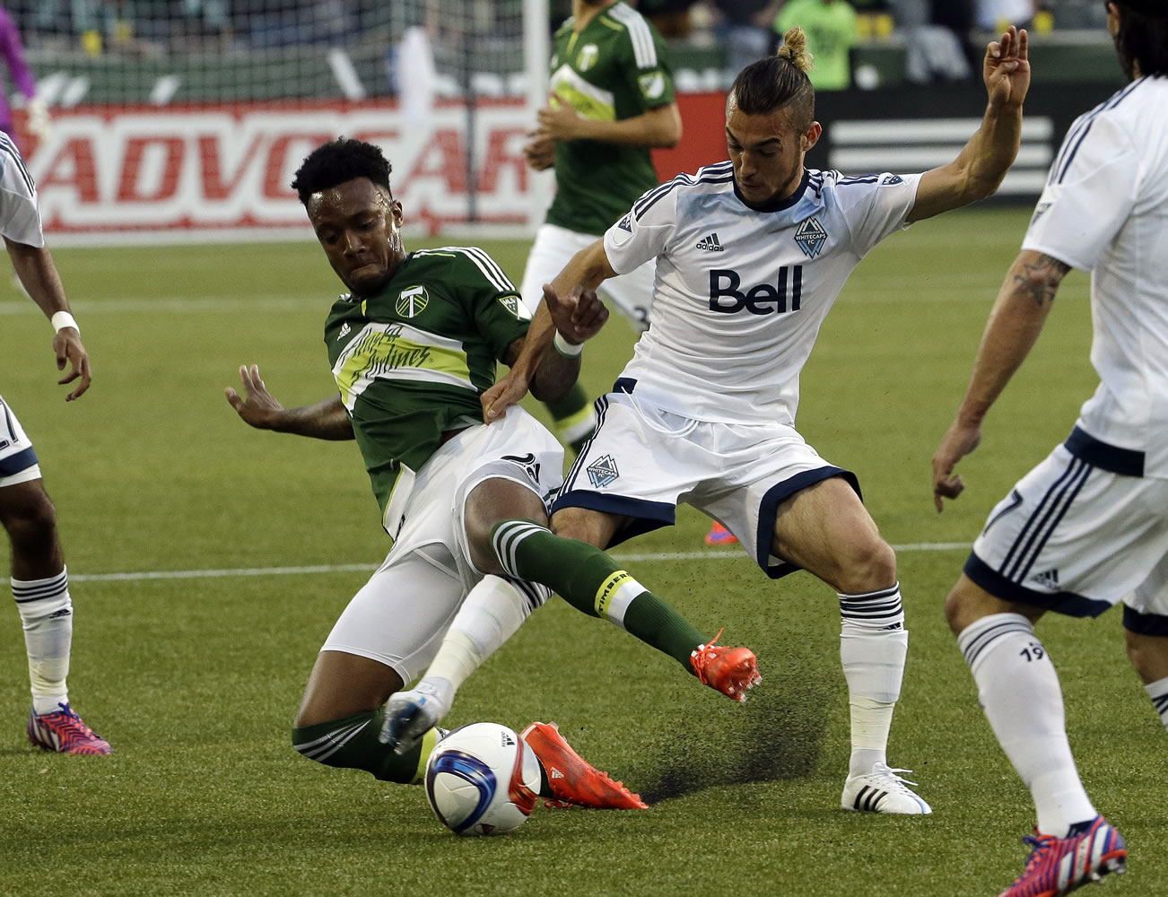 Portland Timbers forward Rodney Wallace, left, battles for the ball against Vancouver Whitecaps midfielder Russell Teibert during the first half of an MLS soccer game in Portland, Ore., Saturday, May 2, 2015.
