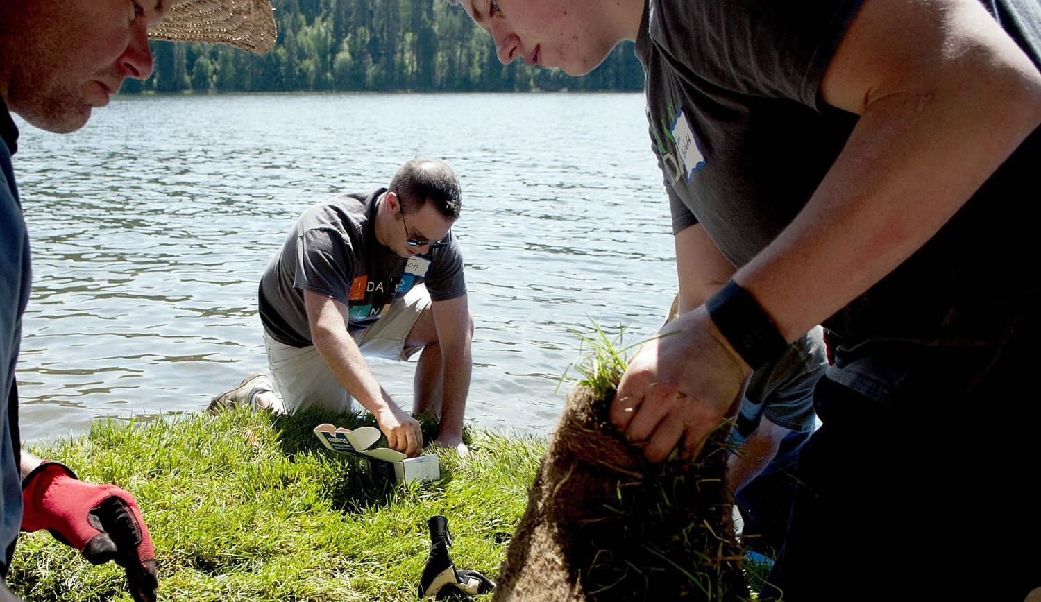 North Idaho College chemistry instructor Jon Downing, center along with Jim Ekins, left of University of Idaho Extension and North Idaho college student Levi Bischoff, right, work Friday to create a floating wetland on Hayden Lake.