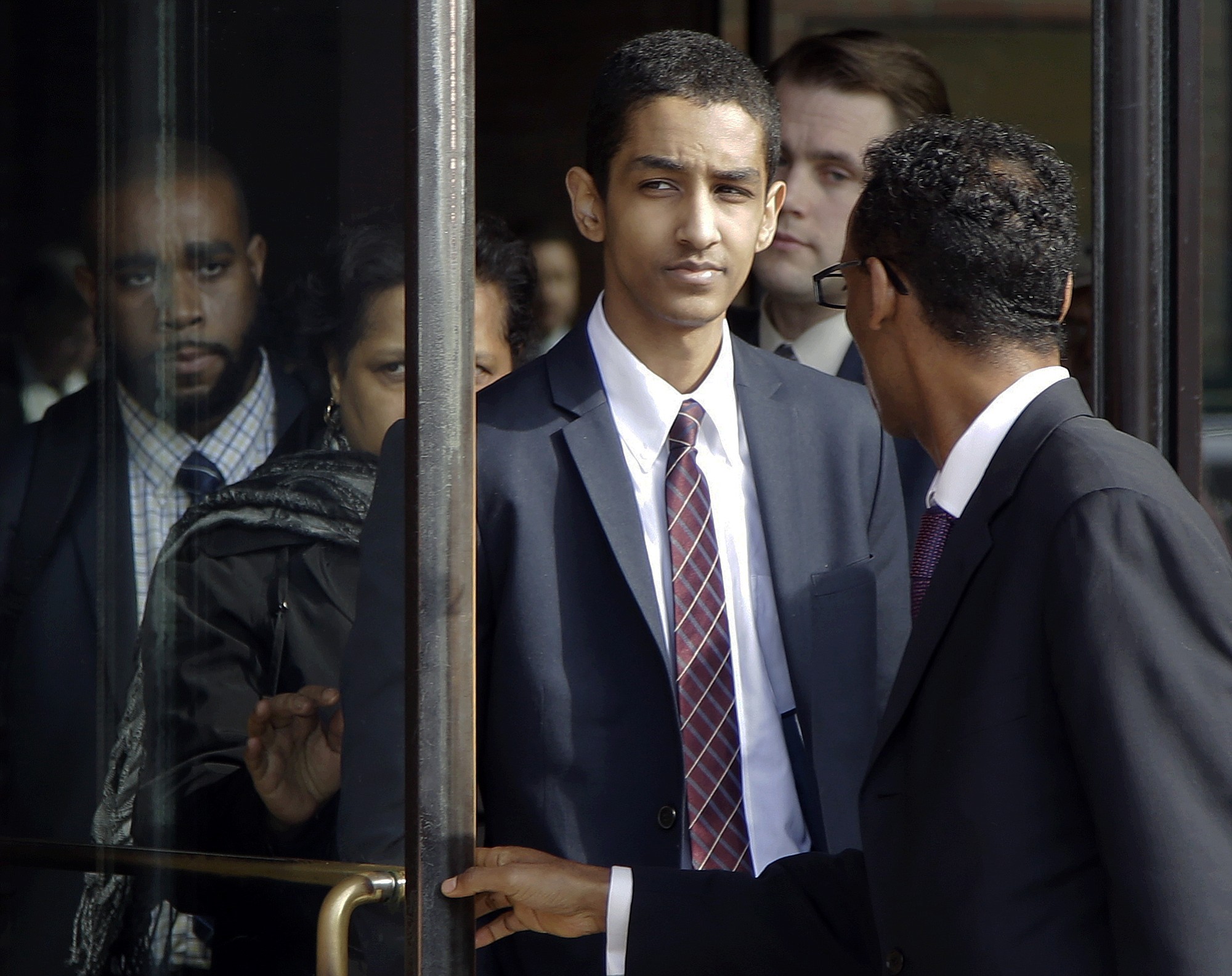 Robel Phillipos, center, departs federal court with defense attorney Derege Demissie, right, after he was convicted in Boston on Tuesday on two counts of lying about being in the dorm room of Boston Marathon bombing suspect Dzhokhar Tsarnaev three days after the bombing in 2013, while two other friends removed a backpack containing fireworks and other potential evidence.