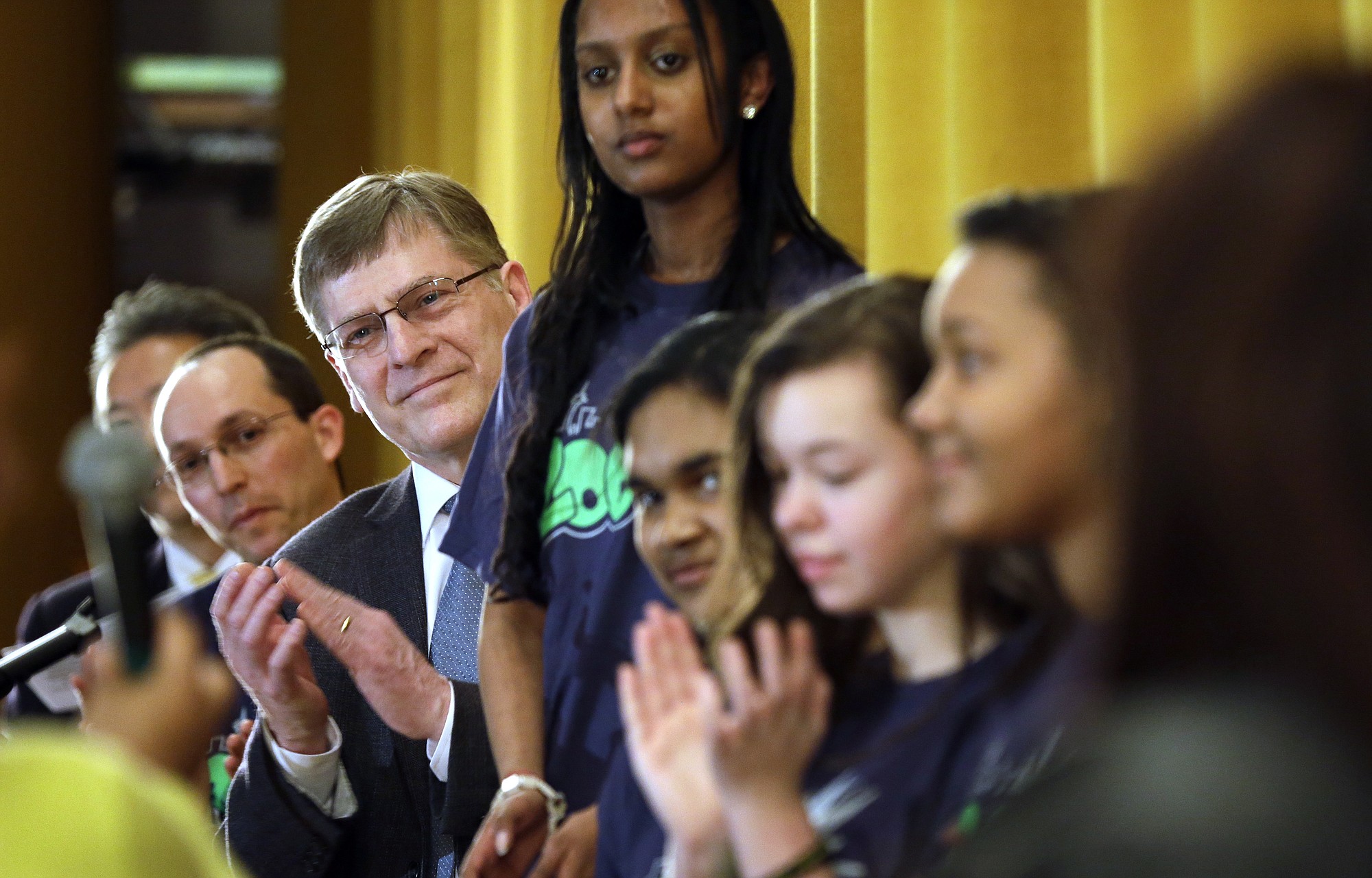 Seattle City Attorney Pete Holmes, center left, applauds at a presentation of a new effort to prevent the use of marijuana and other drugs by teens Wednesday in Seattle.