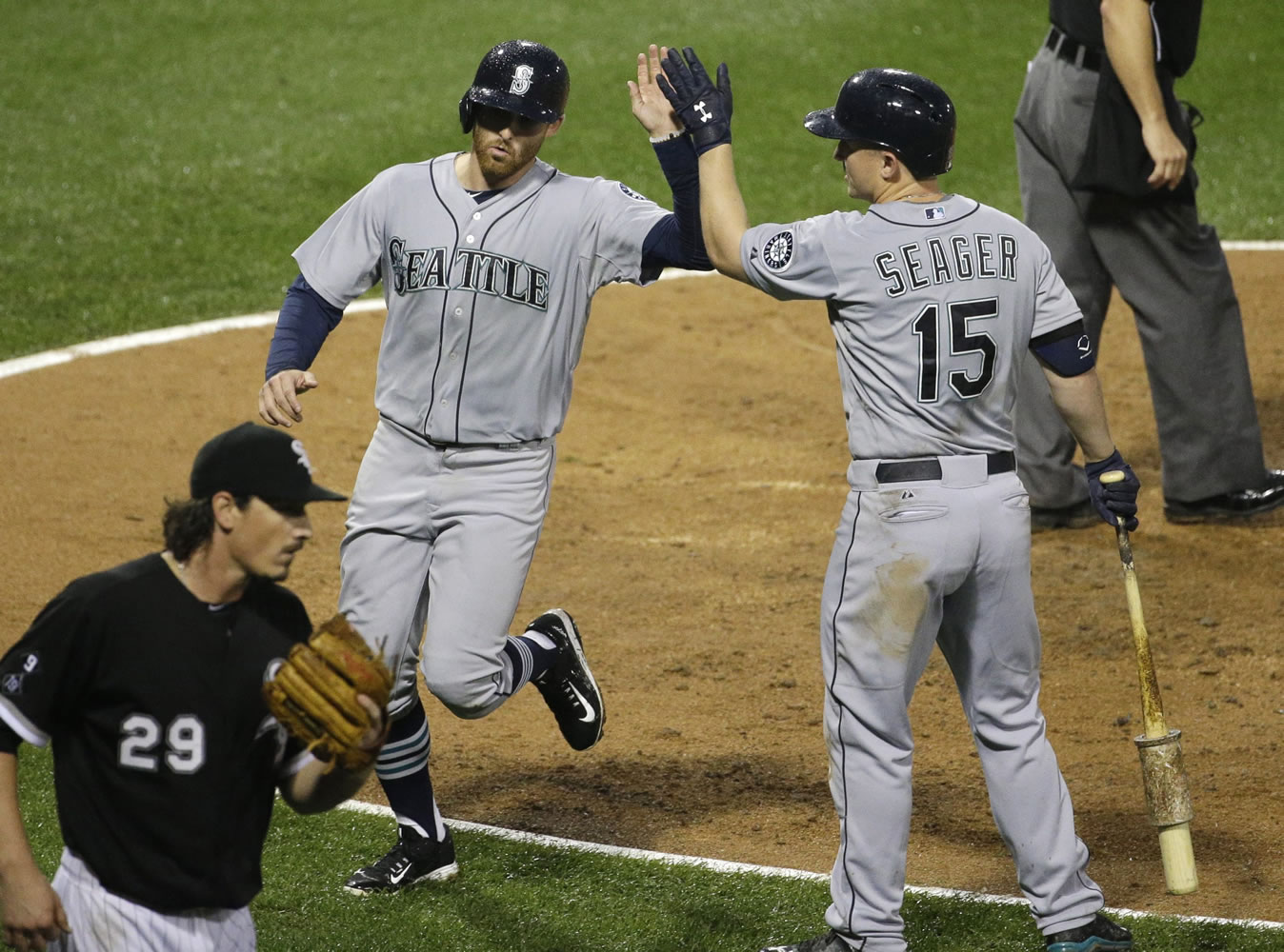 Seattle Mariners' Brad Miller, left, celebrates with Kyle Seager after scoring on a sacrifice fly by Ketel Marte as Chicago White Sox starter Jeff Samardzija reacts during the fourth inning of a baseball game Saturday, Aug. 29, 2015, in Chicago. (AP Photo/Nam Y.
