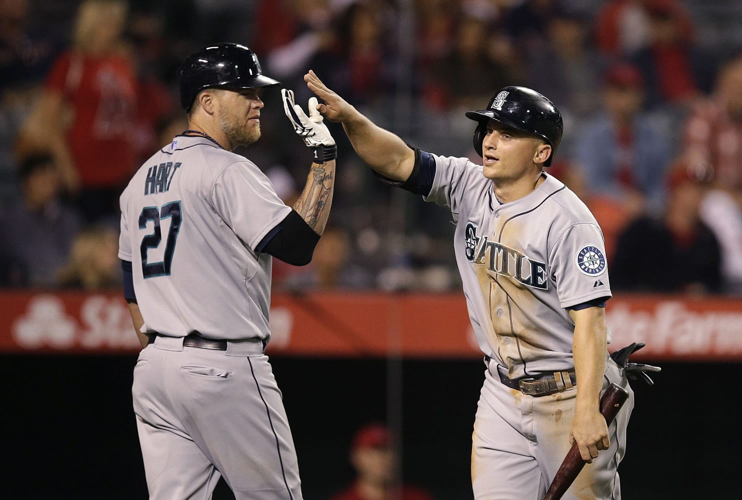 Seattle Mariners' Kyle Seager, right, is greeted by Corey Hart after he scored on a double hit by Logan Morrison during the 12th inning Saturday. (AP Photo/Jae C.