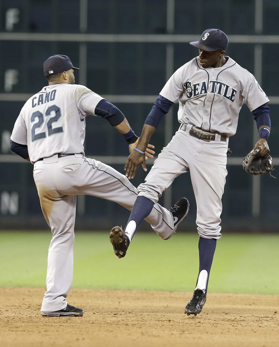 Seattle Mariners' Robinson Cano (22) and James Jones celebrate their 5-2 win over the Houston Astros to sweep the three-game series Wednesday in Houston.