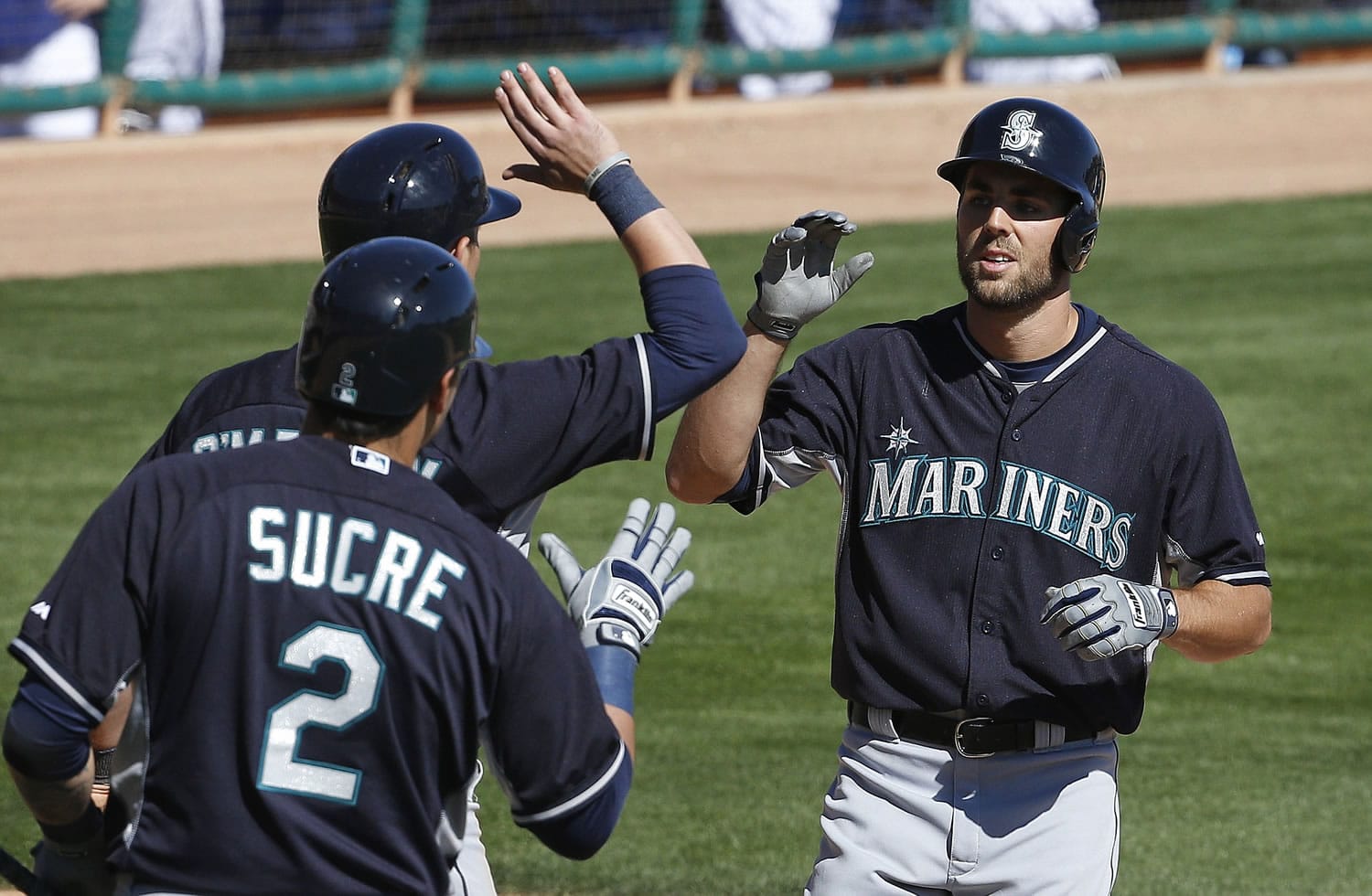 Seattle Mariners' Chris Taylor, right, is congratulated by teammates Jesus Sucre (2) and Shawn O'Malley as Taylor crosses home plate after hitting a home run in the fifth inning of a spring training game against Los Angeles Dodgers, on Friday, March 6, 2015, in Phoenix.