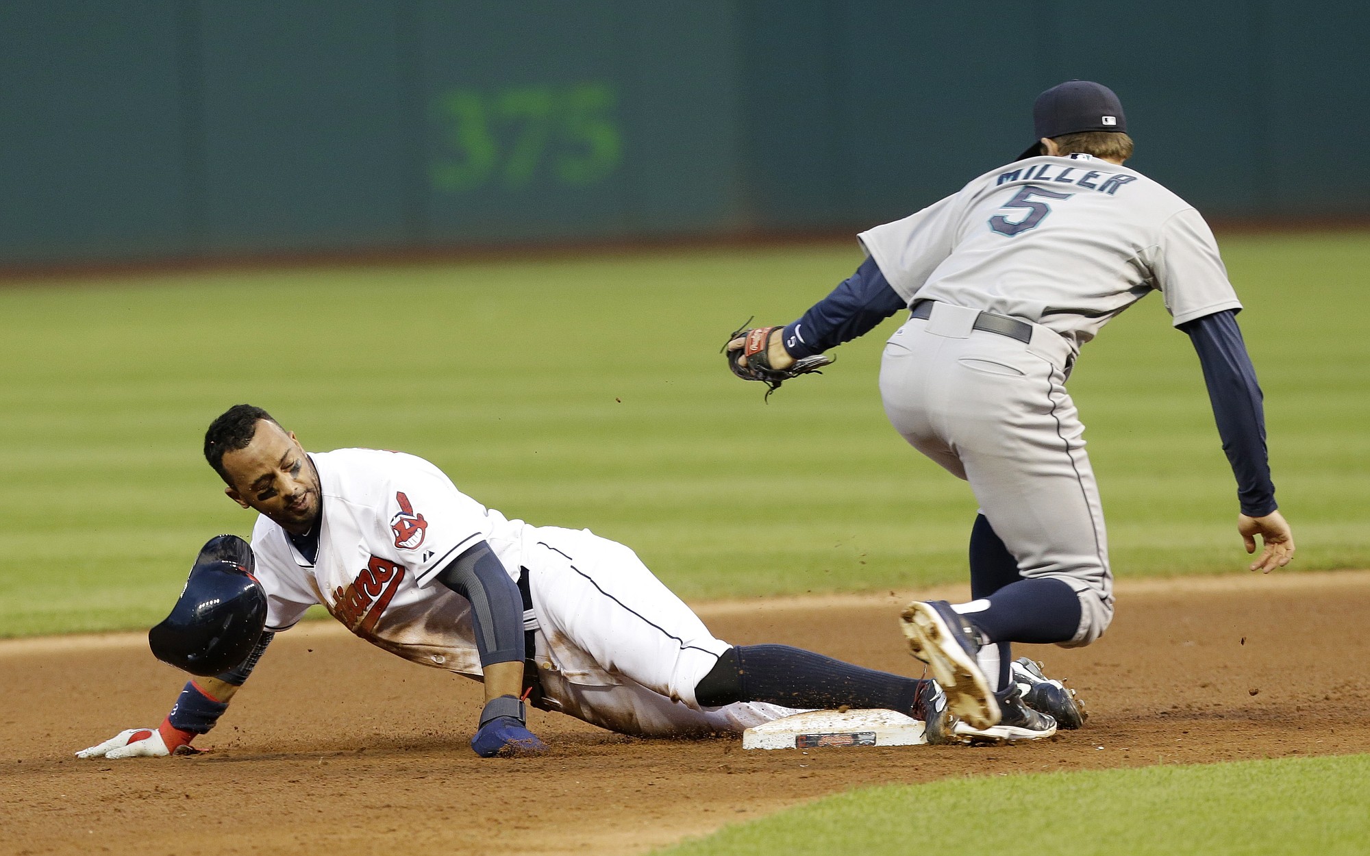 Cleveland Indians' Chris Dickerson, left,  slides safely into second base on a steal as Seattle Mariners' Brad Miller is late on the tag in the fifth inning of a baseball game Wednesday, July 30, 2014, in Cleveland.