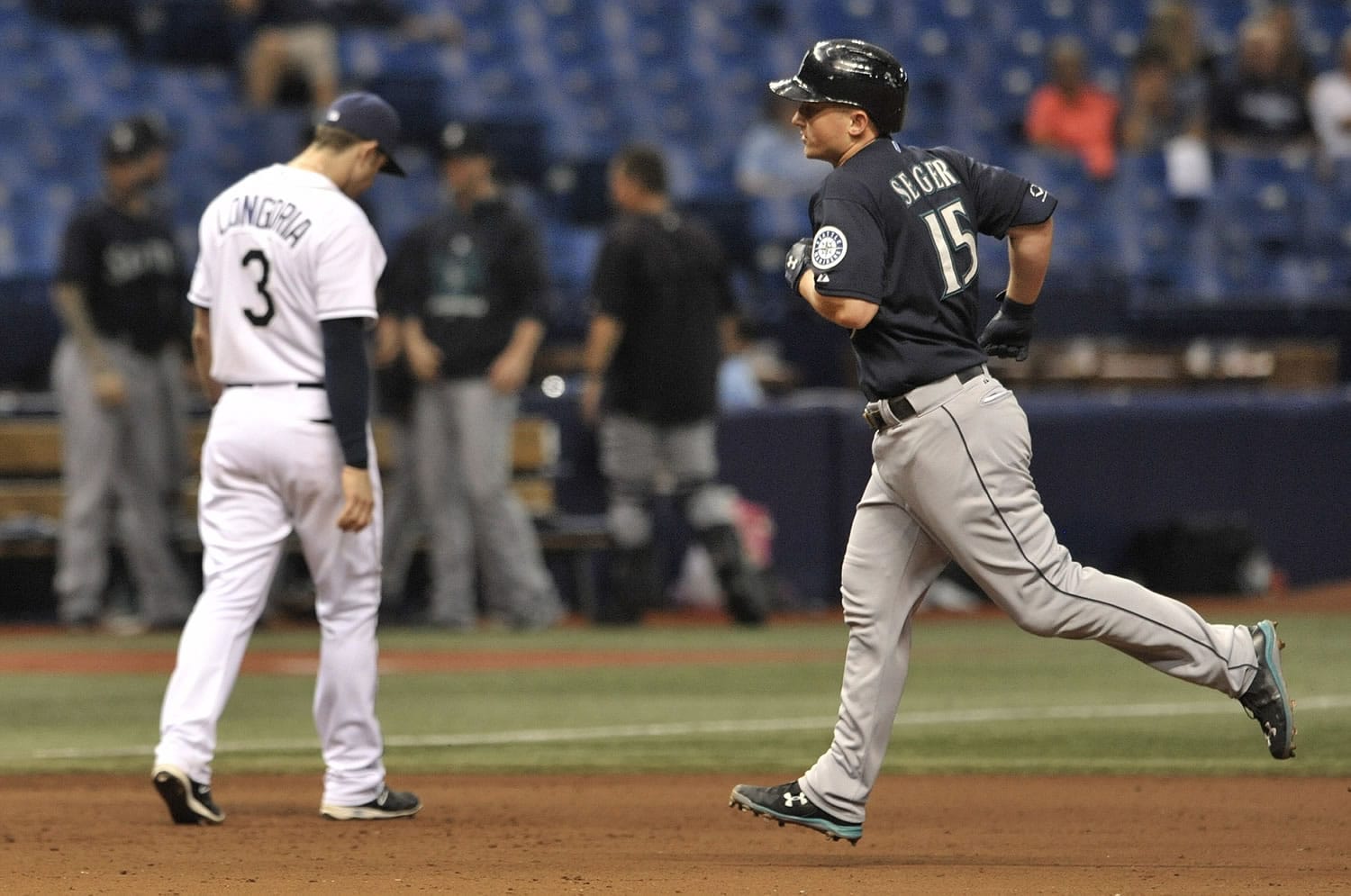 Tampa Bay Rays' Evan Longoria walks back to his position as Seattle Mariners' Kyle Seager circles the bases after hitting a grand slam off Tampa Bay reliever Jake McGee during the eighth inning of a baseball game Tuesday, May 26, 2015, in St. Petersburg, Fla.