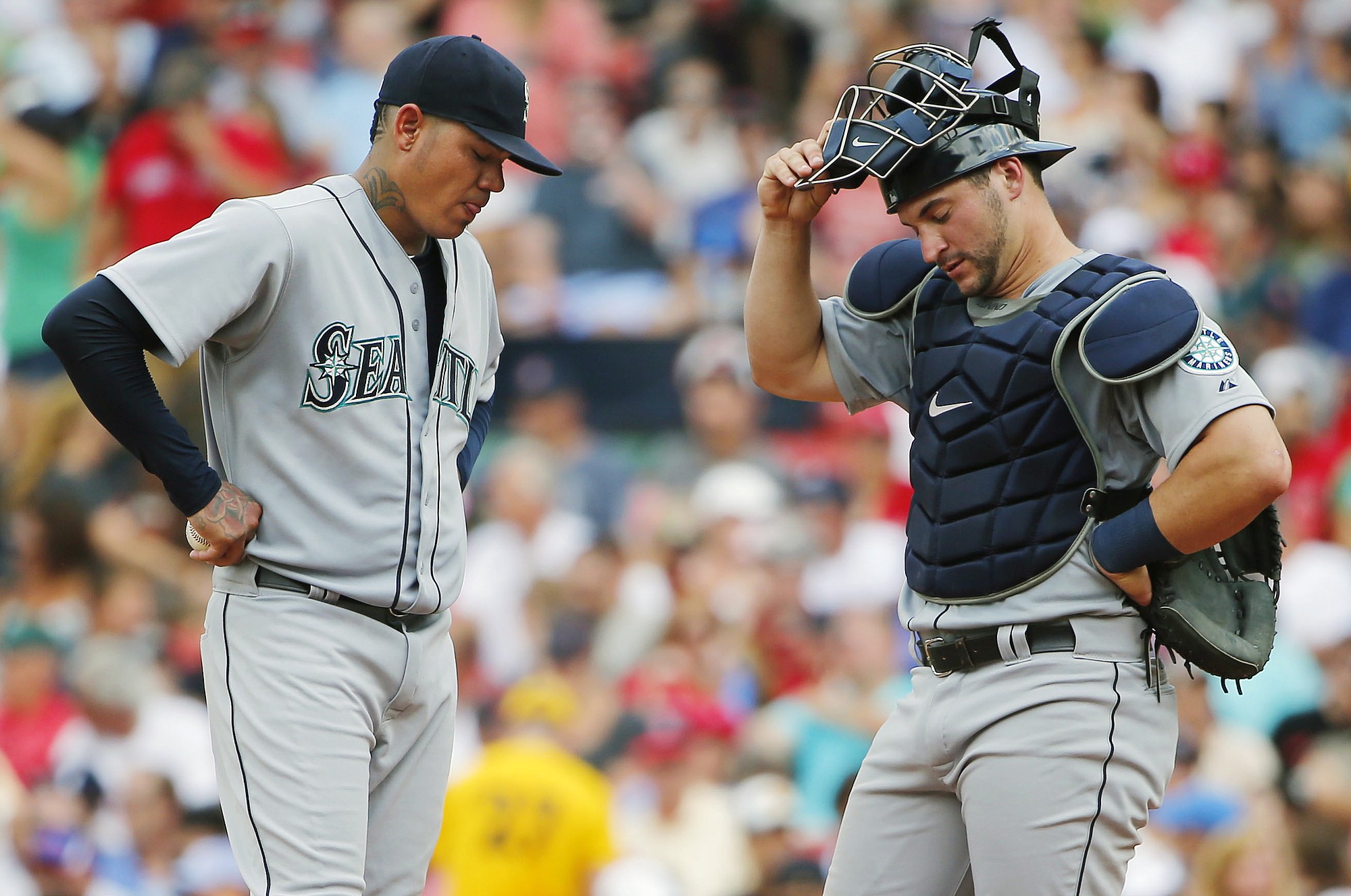 Seattle Mariners starting pitcher Felix Hernandez, left, and catcher Mike Zunino stand on the mound after giving up a run to the Boston Red Sox during the third inning of a baseball game at Fenway Park in Boston Saturday, Aug.