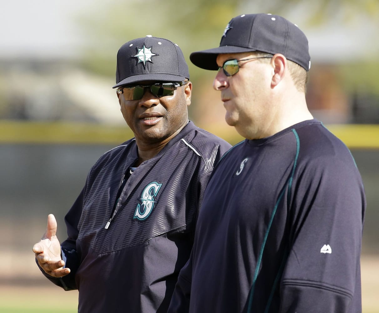 Seattle Mariners manager Lloyd McClendon, left, talks to bench coach Trent Jewett during spring training practice Saturday, Feb. 21, 2015, in Peoria, Ariz.
