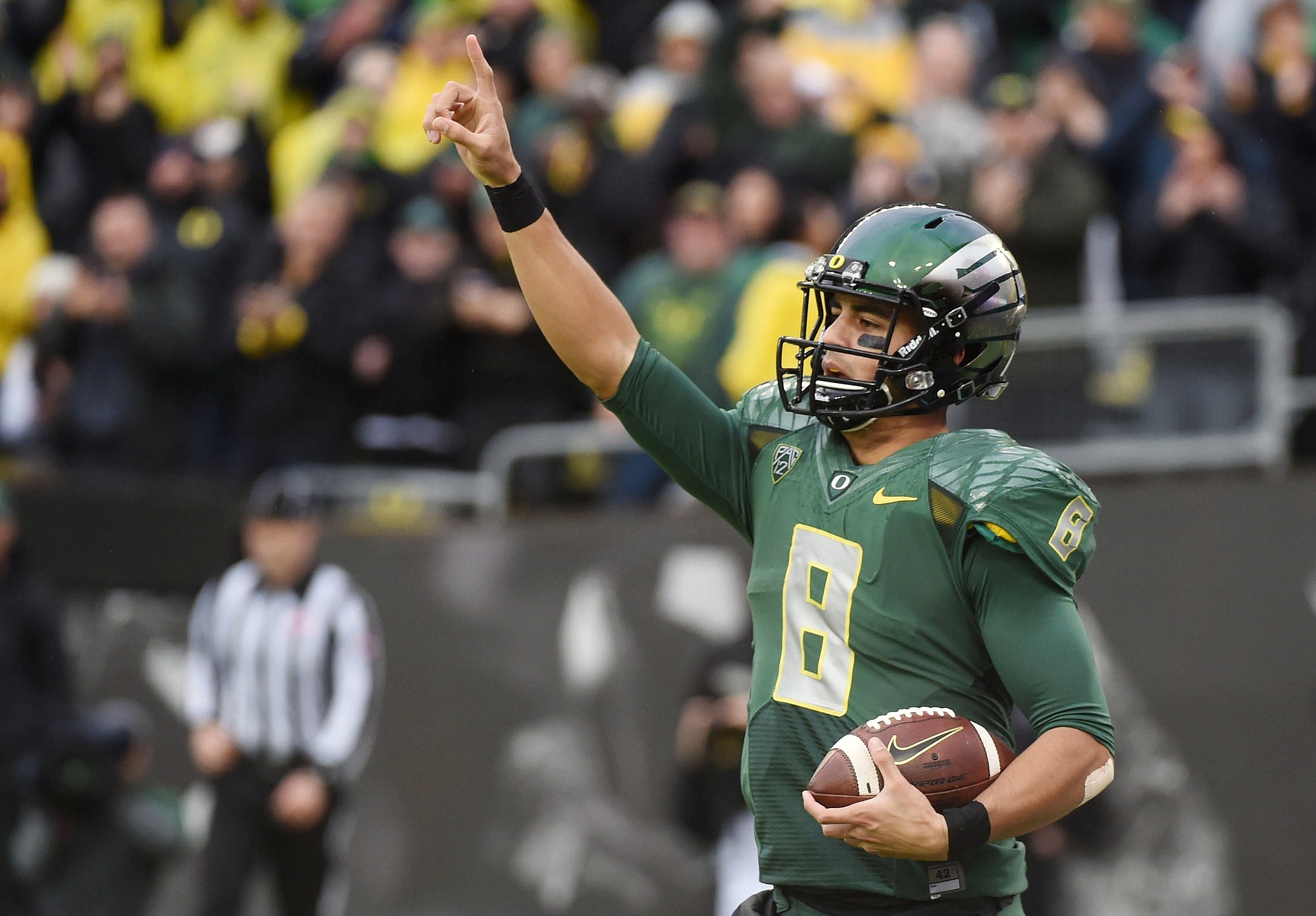 Oregon quarterback Marcus Mariota celebrates after scoring a touchdown during the first quarter of an NCAA college football game against Colorado in November in Eugene, Ore.