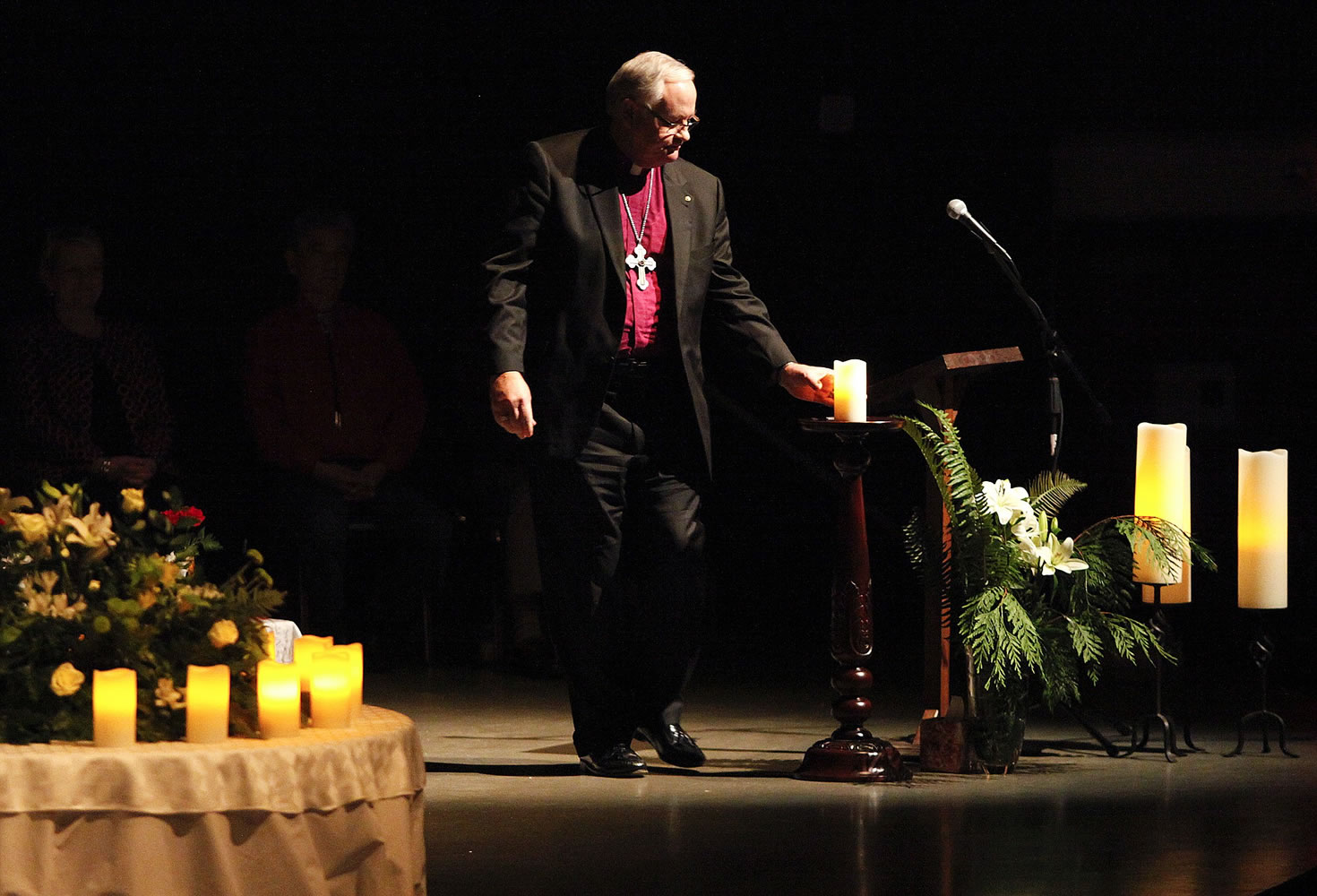Bishop Kirby Unti, representing The Church Council of Greater Seattle, holds a candle during an interfaith candlelight prayer service to honor the four-month anniversary of the Marysville-Pilchuck High School shooting on Tuesday in Marysville.