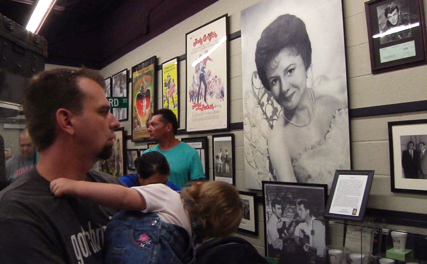 A fan looks at a young glamour shot of actress Betty Lynn at the Andy Griffith Museum in Mount Airy, N.C, on Friday, July 17, 2015. Every third Friday of the month, the 88-year-old star, who played Thelma Lou on Griffith's iconic television show, greets visitors to the museum by signing autographs, taking photos and blowing kisses.