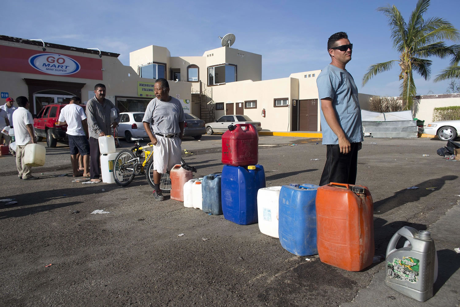 People wait in line to fill up their jugs and bottles with fuel at a gasoline station in San Jose de los Cabos, Mexico, on Thursday.