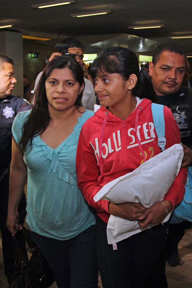 Associated Press files
Houston resident Dorotea Garcia, left, and Alondra Diaz, 13, are escorted by police early Saturday into the airport in Guadalajara, Mexico, for their flight to the United States.