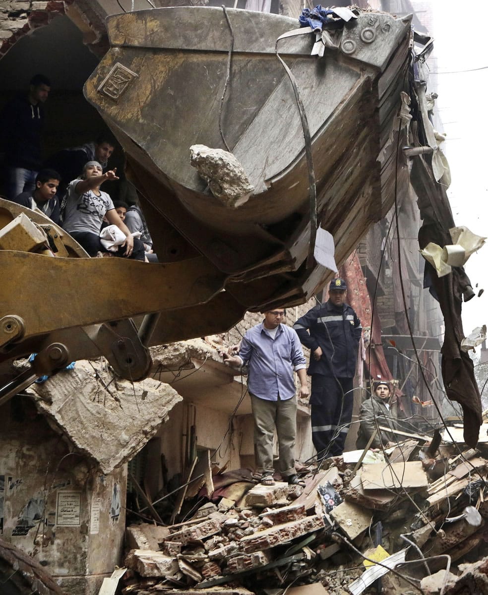 Volunteers search for survivors in the rubble of a building that collapsed in the Cairo suburb of Matareyya early Tuesday.