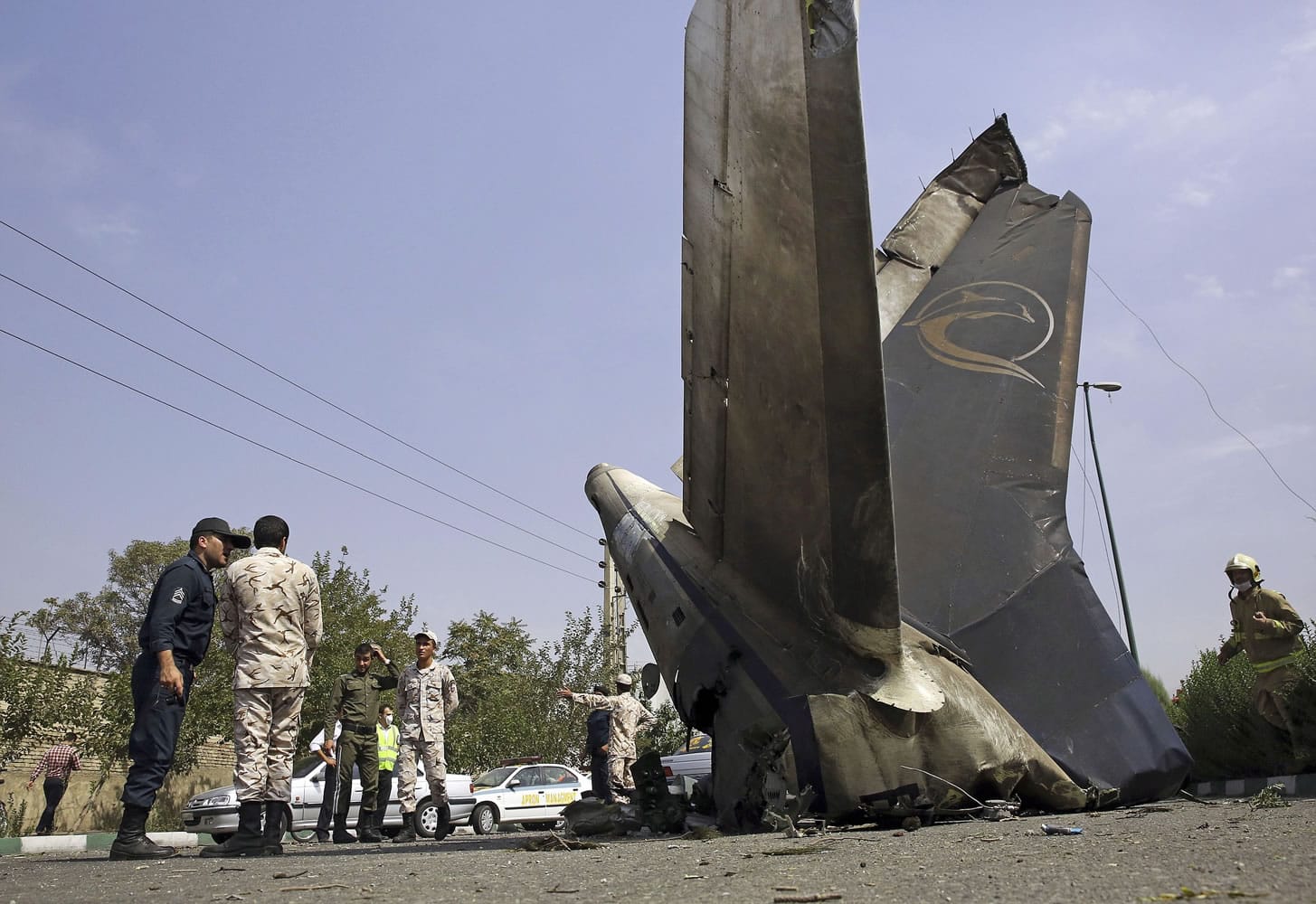 Iranian Revolutionary Guards inspect the site of a plane crash Sunday near Tehran, Iran.
