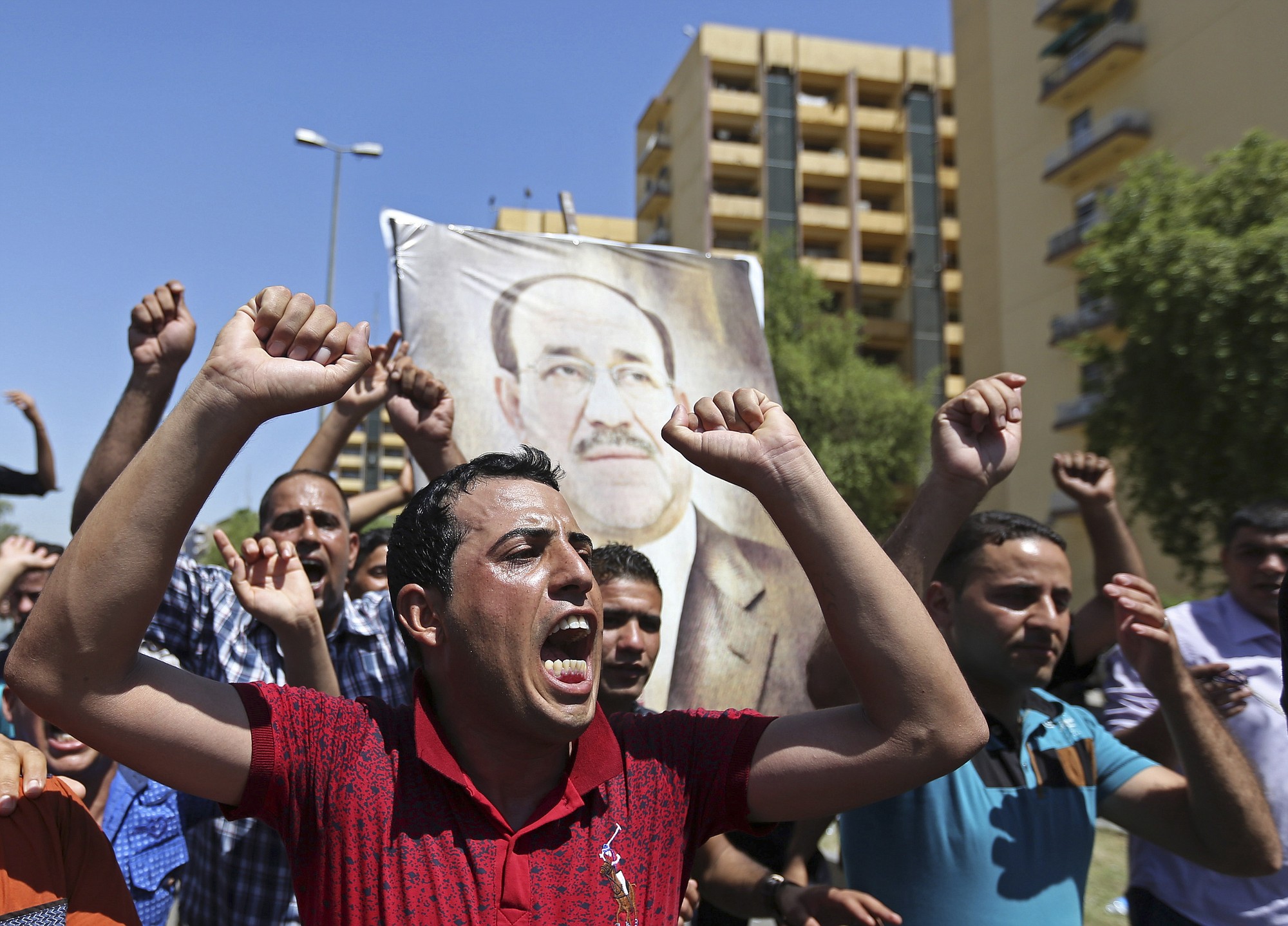Iraqis chant pro-government slogans and display placards bearing a picture of embattled Prime Minister Nouri al-Maliki during a demonstration in Baghdad, Iraq, on Monday.