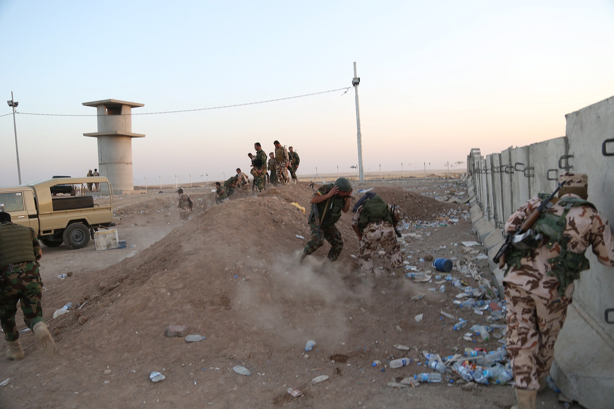 Kurdish Peshmerga fighters take cover Friday during airstrikes targeting Islamic State militants near the Khazer checkpoint outside of the city of Irbil in northern Iraq. Iraqi Air Force has been carrying out strikes against the militants, and for the first time on Friday, U.S.