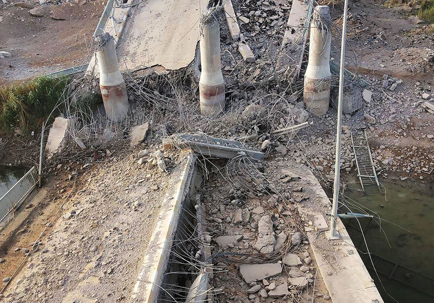 Associated Press
A destroyed bridge over the Euphrates River is shown Wednesday in northern Ramadi, Iraq. The Islamic State group destroyed the bridge with a car bomb to cut the northern entrance to the city, locals said.